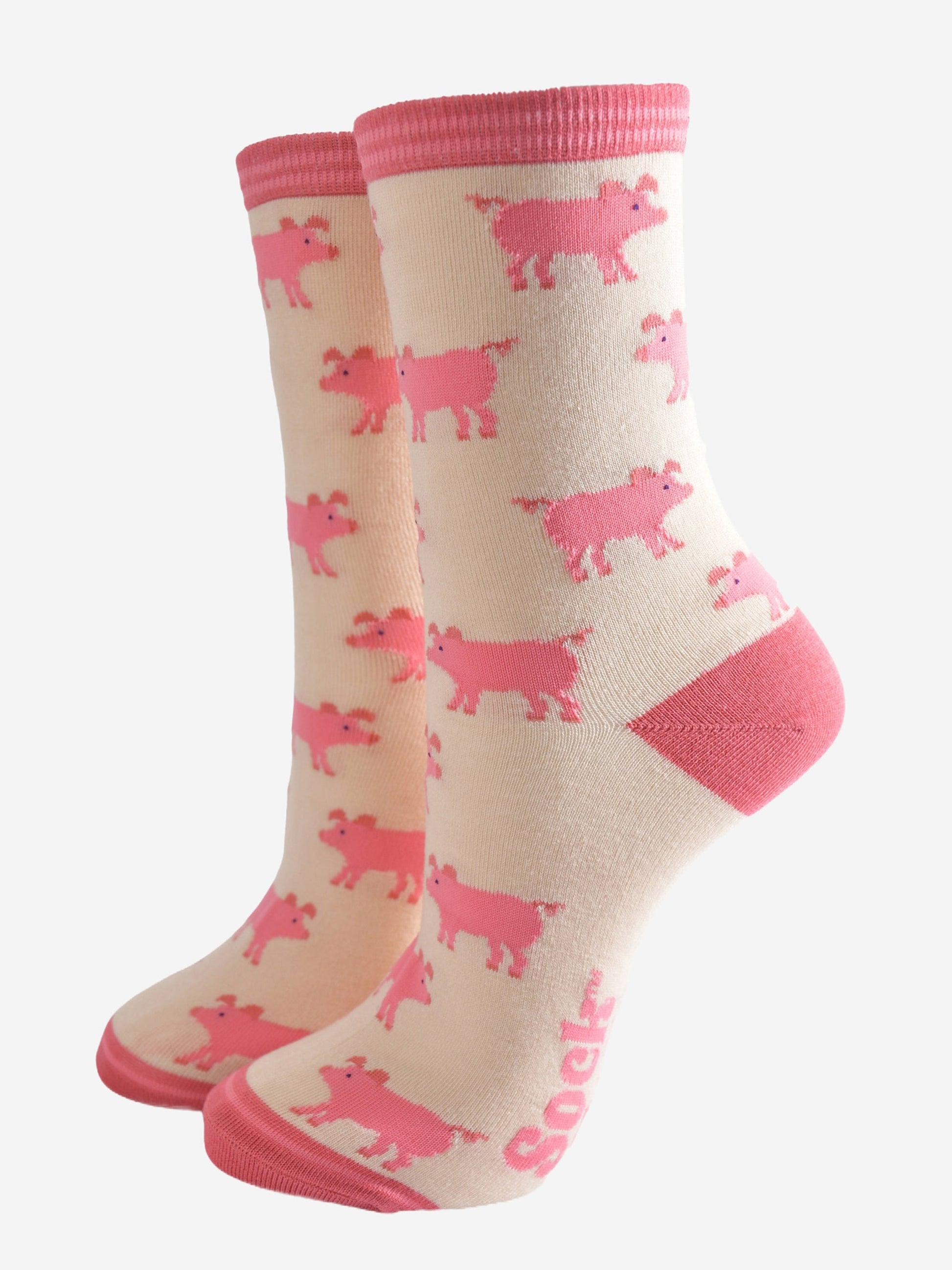 cream and pink bamboo socks with an all over pattern of pink pigs. the socks have a pink toe, heel and cuff
