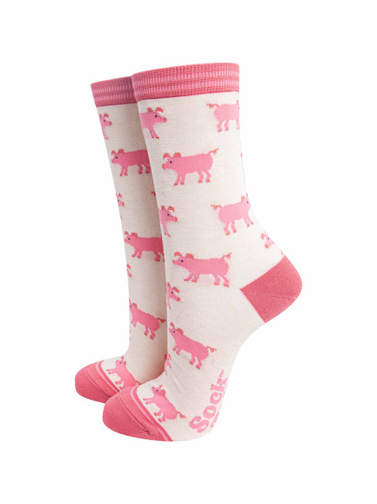 cream and pink bamboo socks with an all over pattern of pink pigs. the socks have a pink toe, heel and cuff