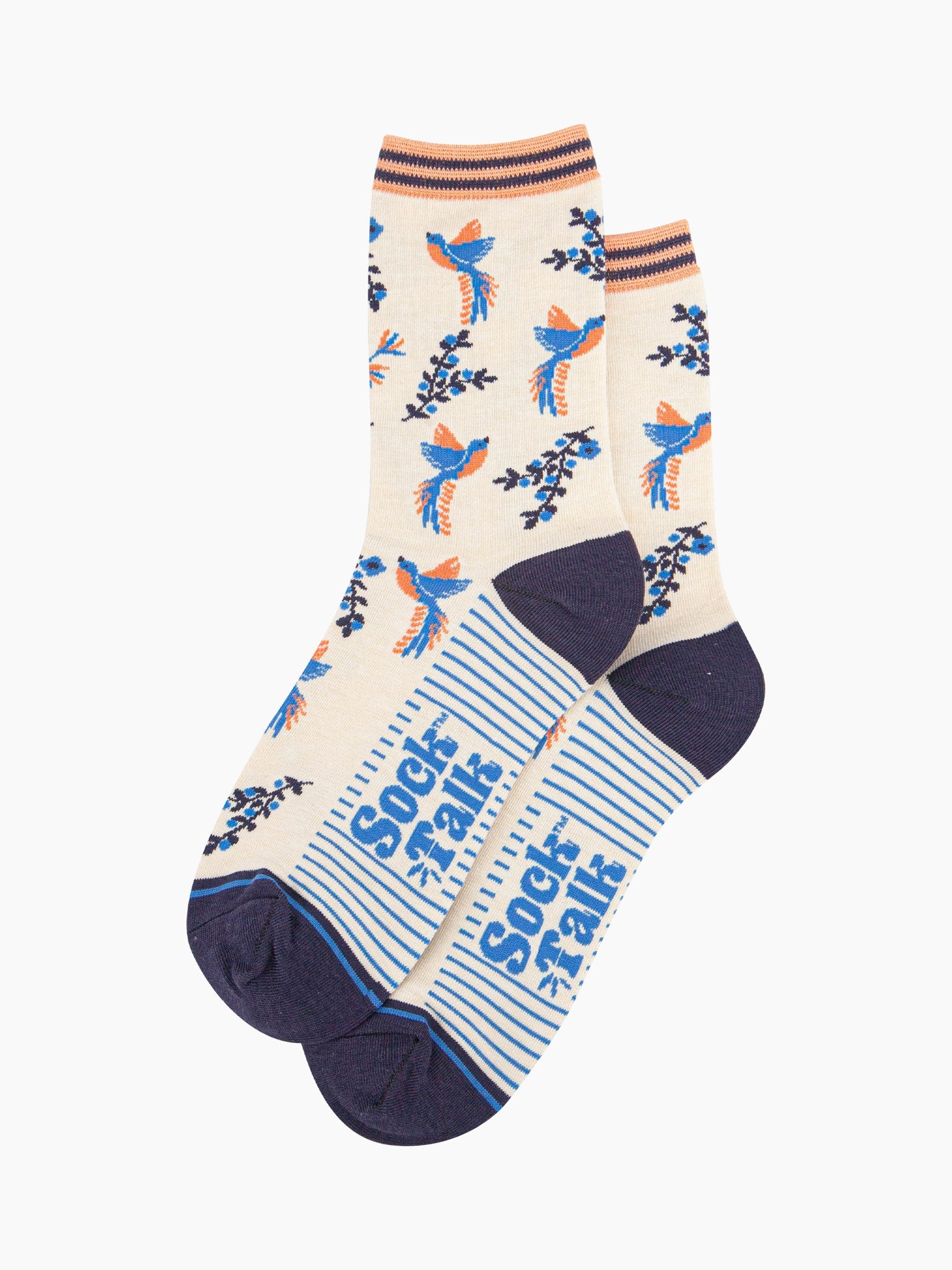 pair of cream and blue hummingbird socks laying flat, one overlapping the other. showing clearly the cream background of the socks which is contrasted by blue and orange hummingbirds. the sock talk logo is visible on the base of the sole. 