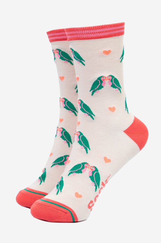 cream bamboo ankle socks with a pattern of green kissing love birds and pink love hearts. the socks have a pink toe, heel and pink striped cuff