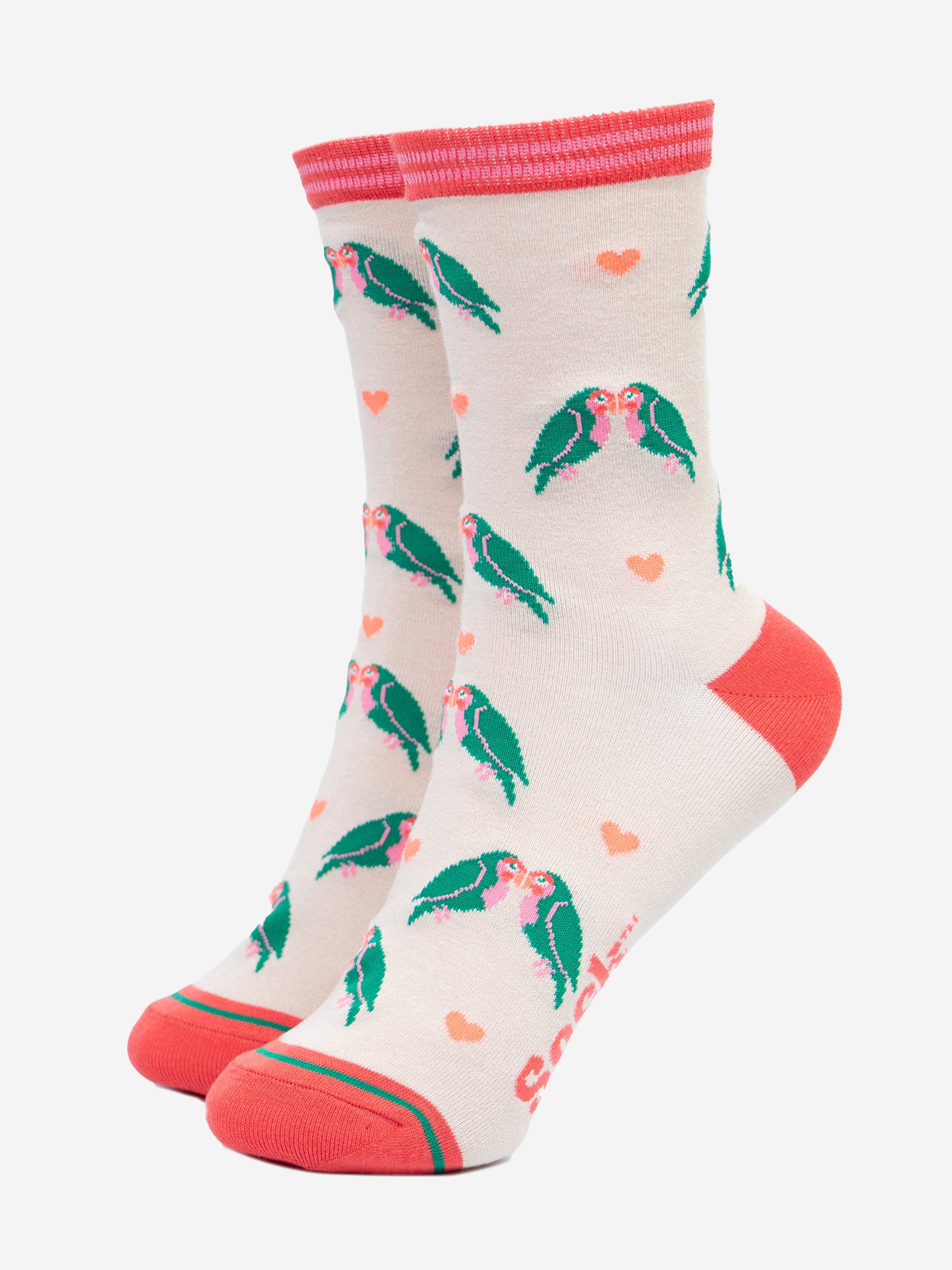 cream bamboo ankle socks with a pattern of green kissing love birds and pink love hearts. the socks have a pink toe, heel and pink striped cuff