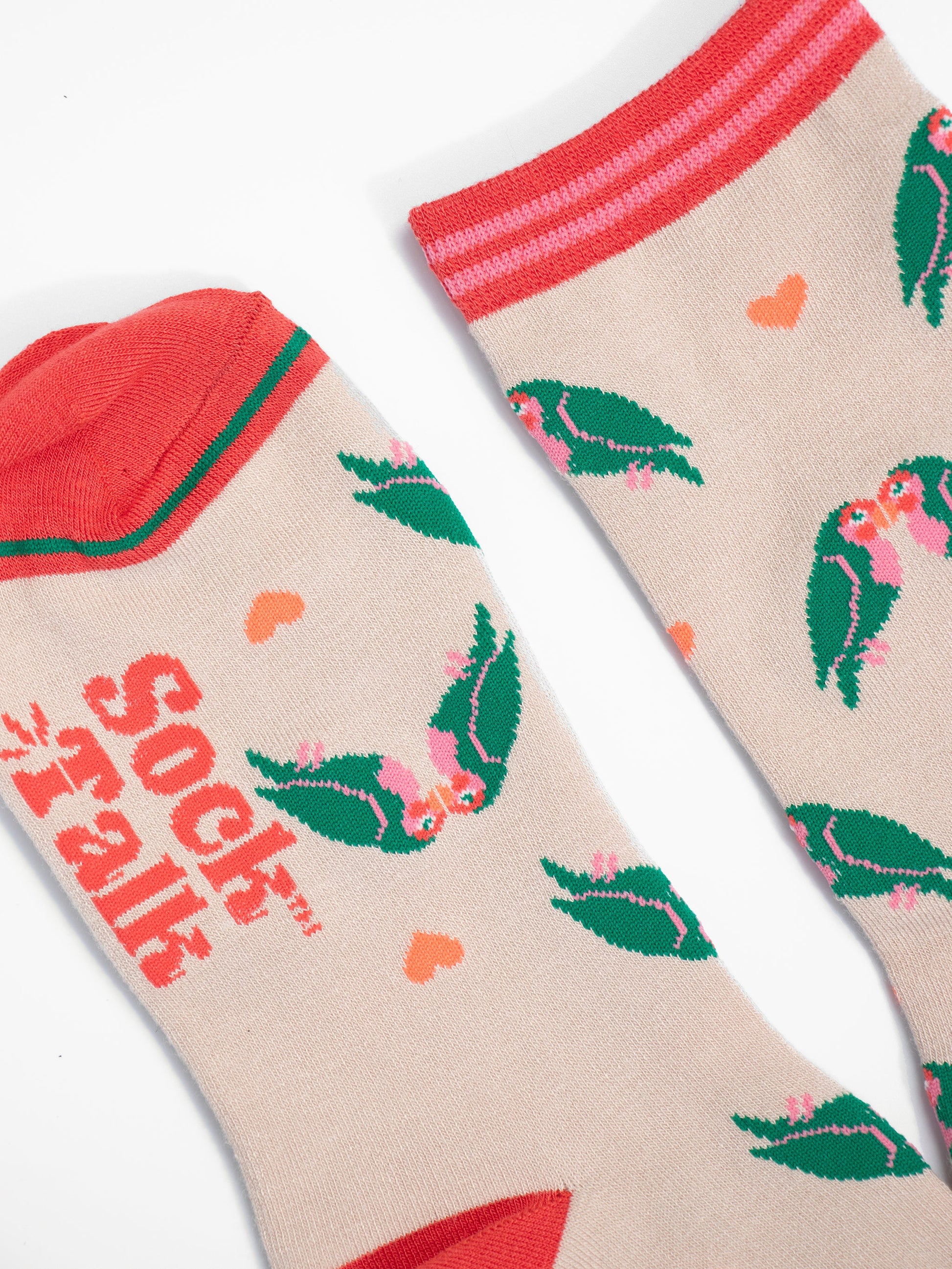 close up of the toe and cuff, the toe is a coral pink with a green border stripe, the cuff is pink and coral striped