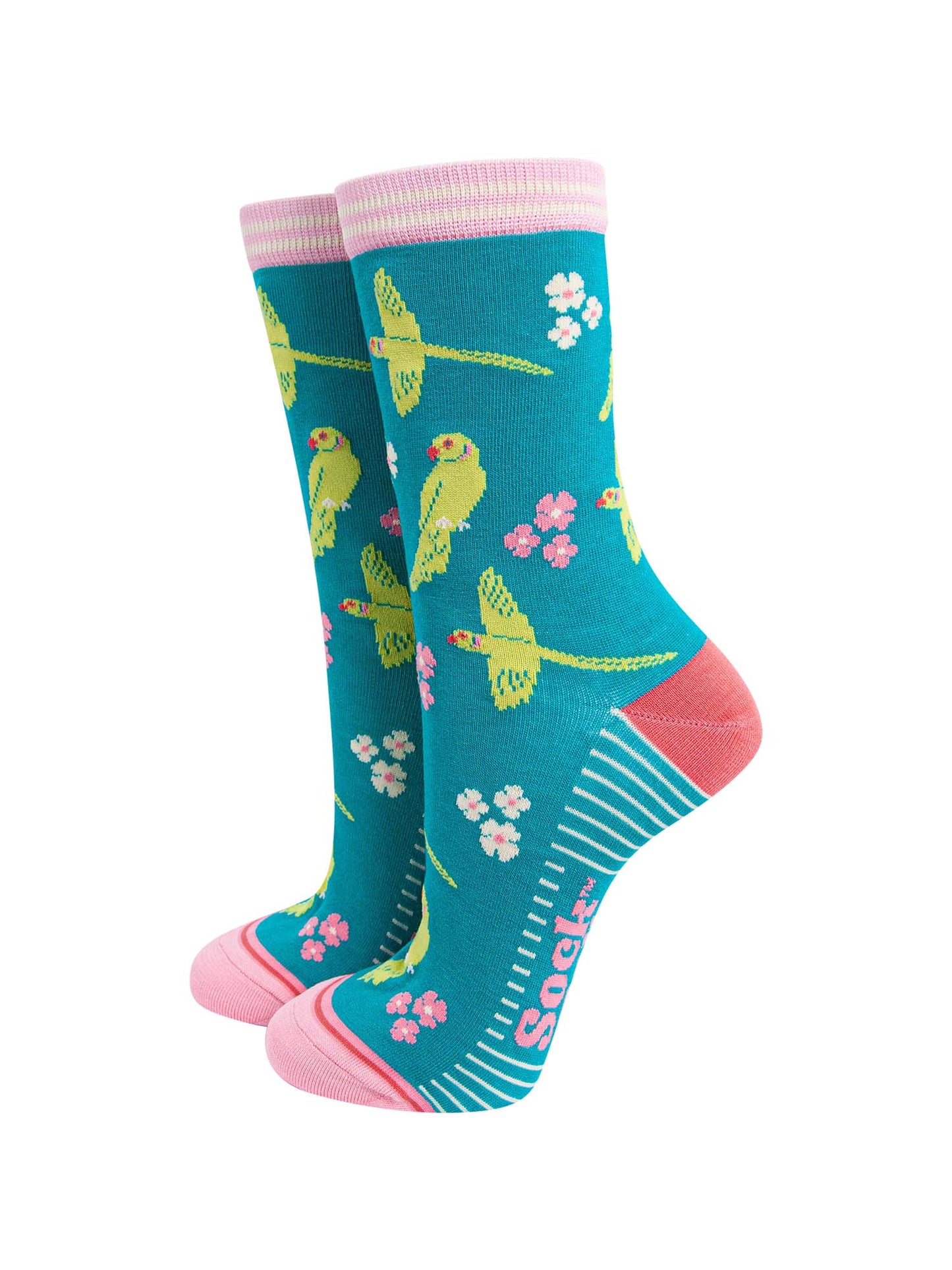 teal bamboo socks with a pattern of flying and perching ring necked parakeets and flowers. the heel and toe are a light coral pink, the cuff is pink and white striped.