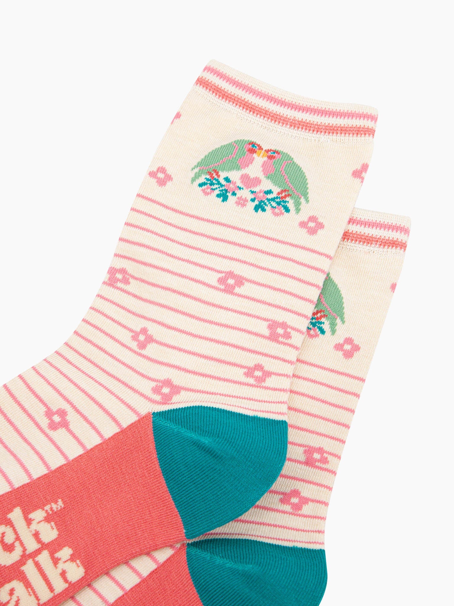 close up of the pattern. there are two green and pink love birds kissing with their beaks. they are perched on a branch of blue leaves and pink flowers. in between the love birds there is a pink love heart. 