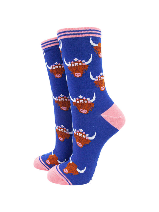 royal blue bamboo socks with pink heel, toe and cuff featuring an all over pattern of highland cows wearing floral crowns
