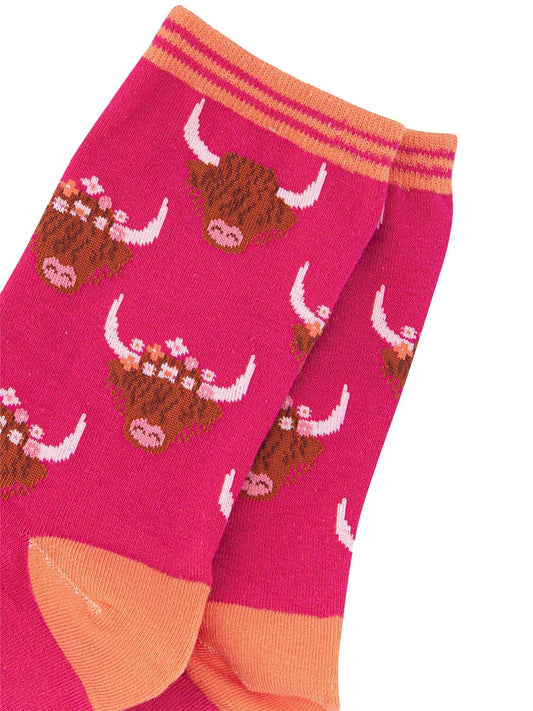 close up of the highland cows wearing floral wreaths as crowns
