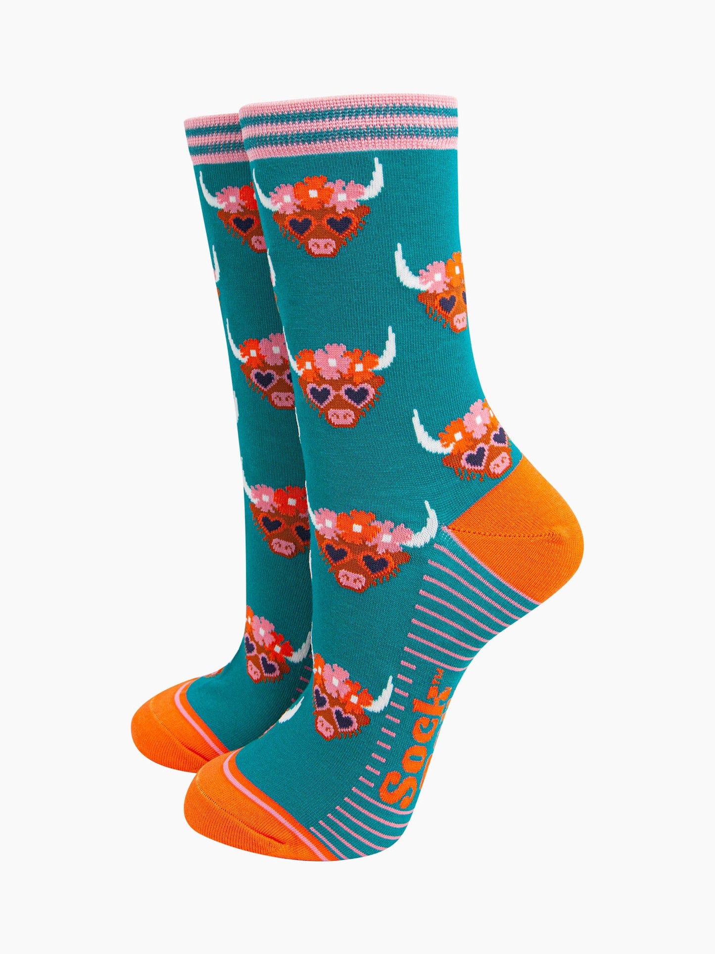 teal bamboo socks with an all over pattern of highland cows wearing floral crowns and love heart shaped sunglasses.