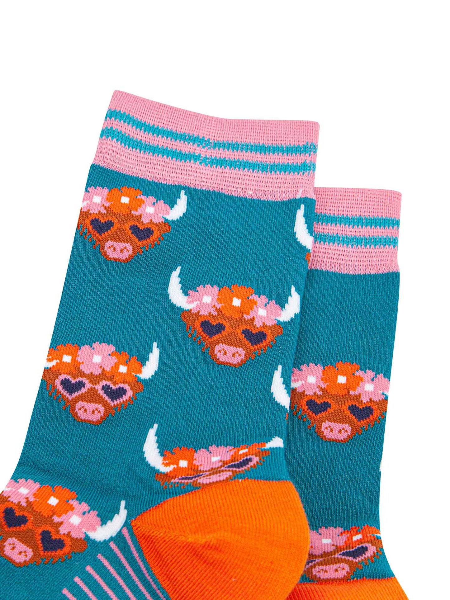 close up of the pattern. the highland cow faces are brown, they have white pointed horns and wear pink love heart sunglasses. on the heads of the cows is a floral wreath composed of pink and orange flowers. the cuff is teal and light pink striped.