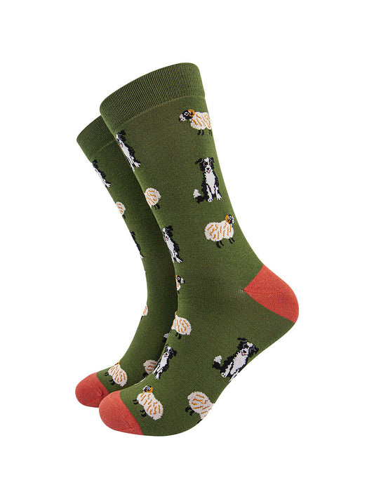dark green socks with an orange heel and toe with an all over pattern of black and white border collie dogs and sheep