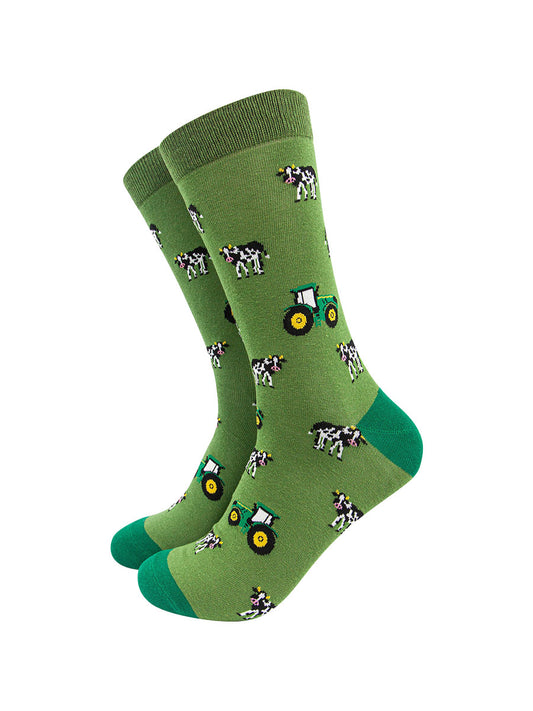 green dress socks with an all over pattern of green tractors and black and white cows