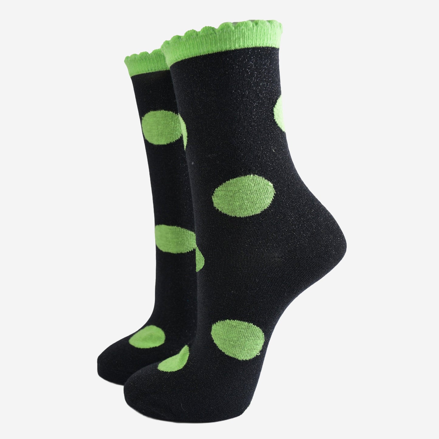 black socks with a large lime green polka dot pattern and scalloped cuff