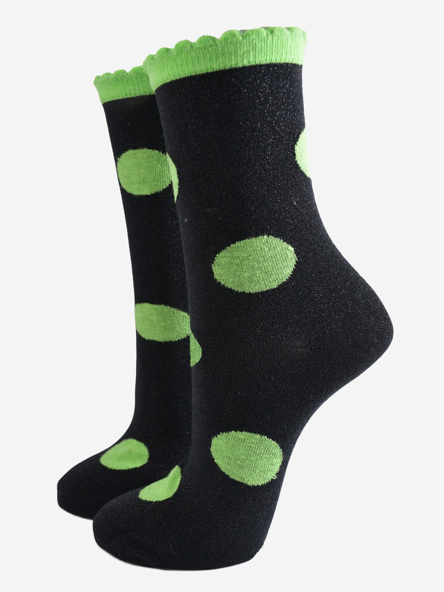 black socks with a large lime green polka dot pattern and scalloped cuff