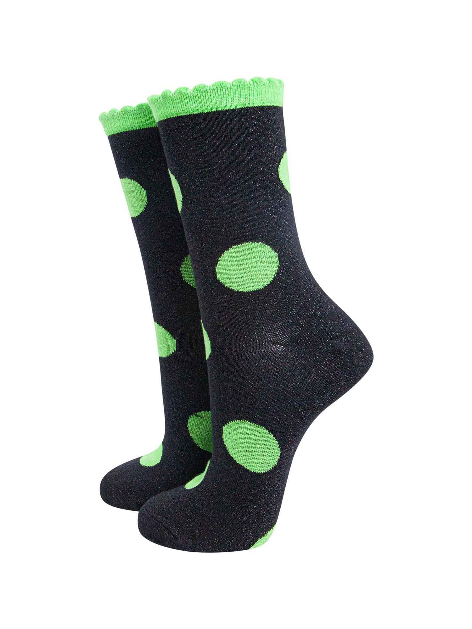 black socks with a large lime green polka dot pattern and scalloped cuff