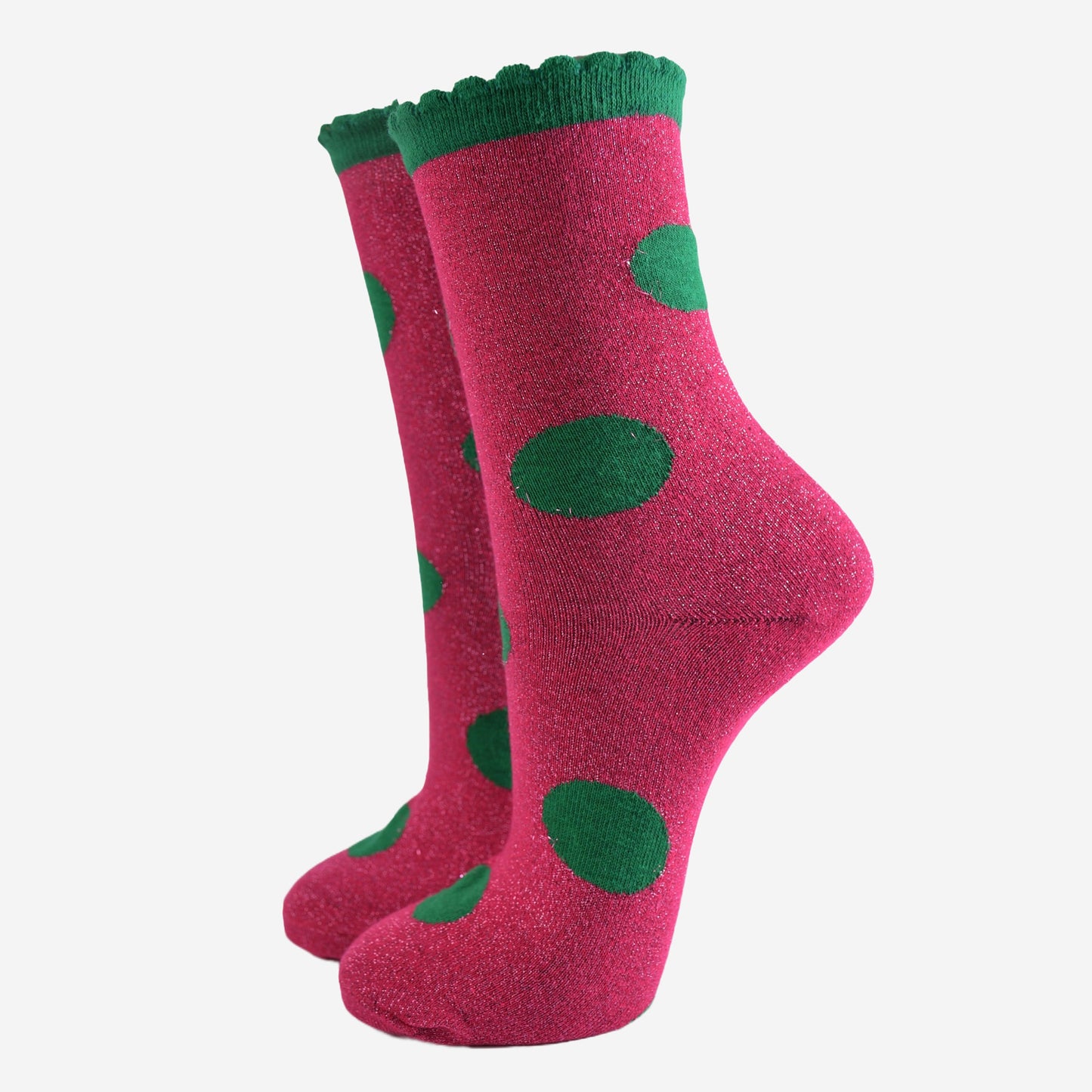 pink socks with a large green polka dot pattern and scalloped cuff