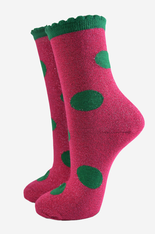 pink socks with a large green polka dot pattern and scalloped cuff