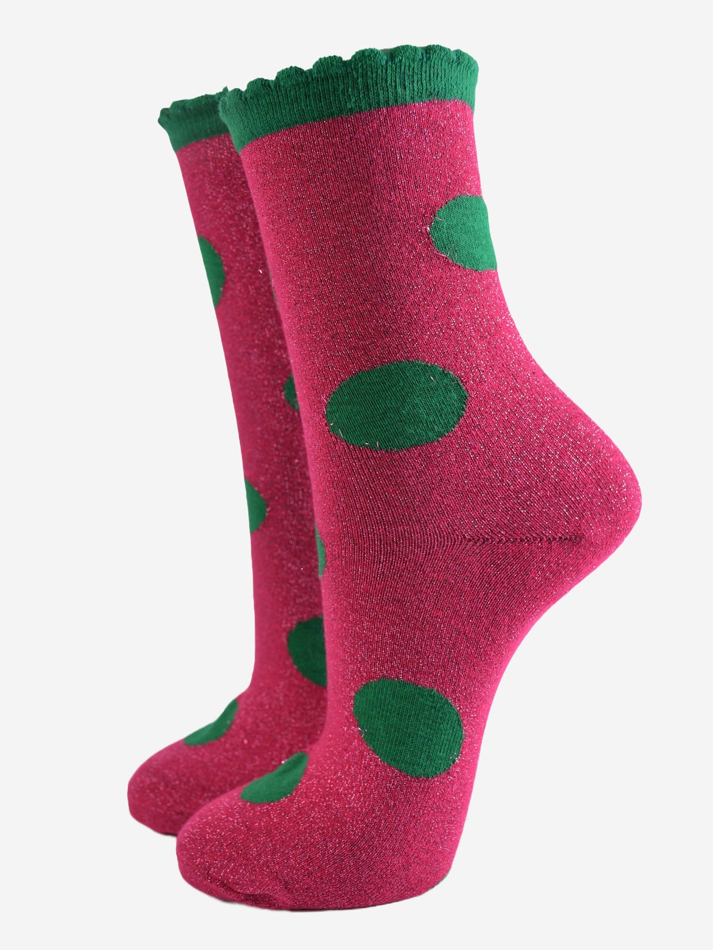 pink socks with a large green polka dot pattern and scalloped cuff