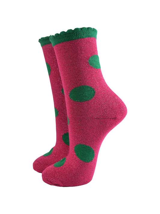 pink socks with a large green polka dot pattern and scalloped cuff