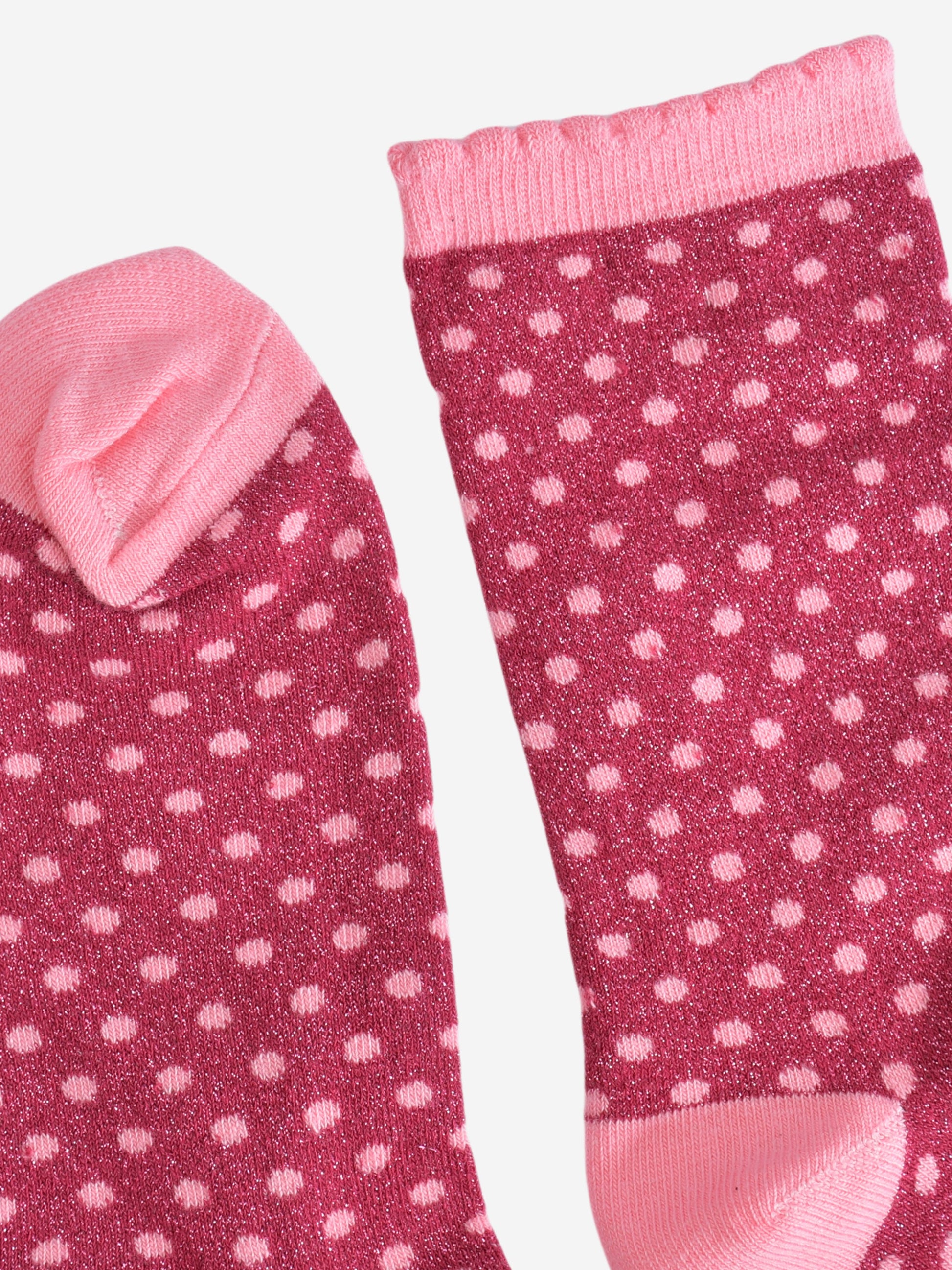 showing the cuff and the toe of the polka dot socks, both are light pink like the polka dots. the cuff has a scalloped edge