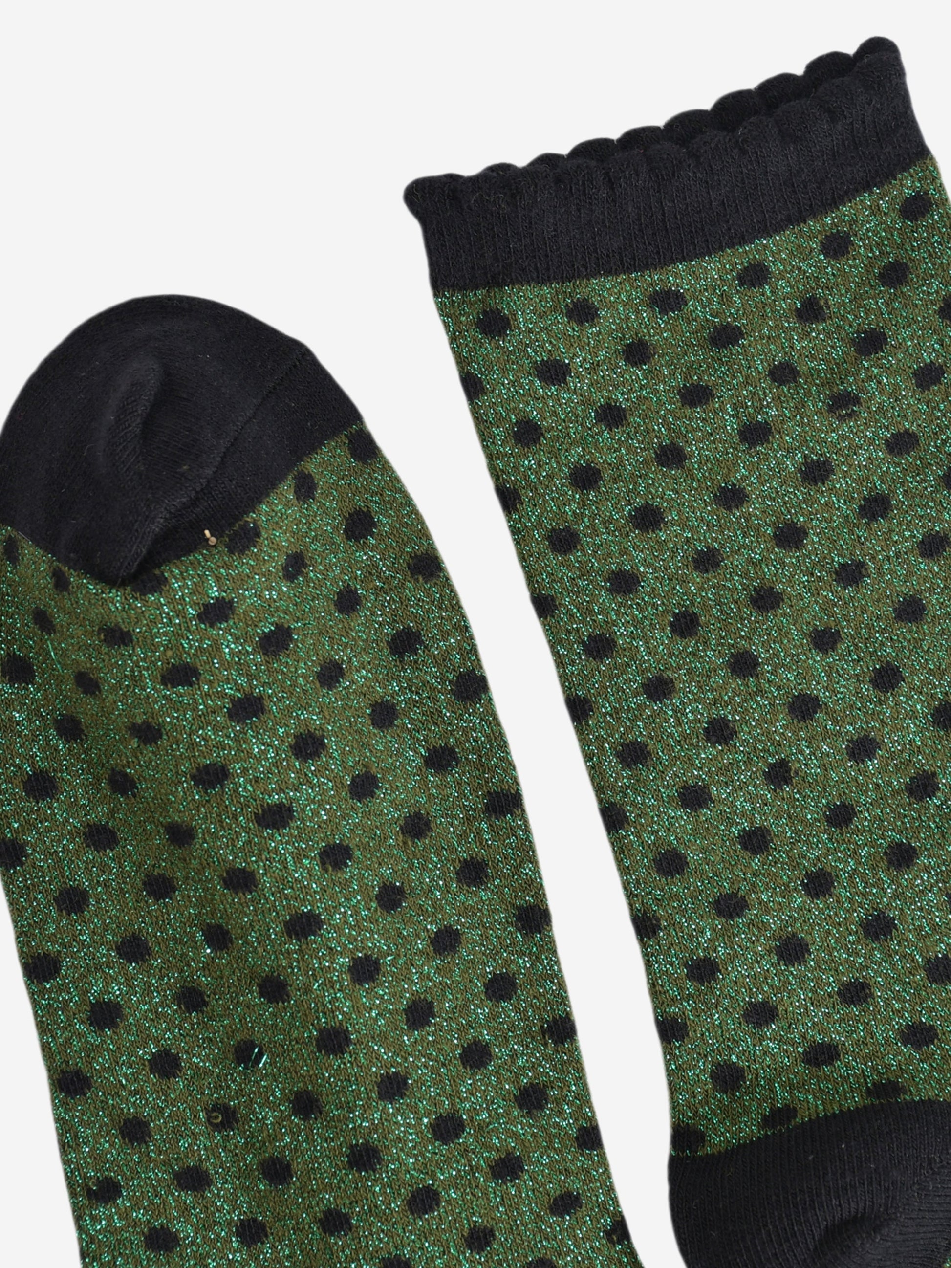 close up of the cuff and toe of the socks, they are both black and the cuff is scalloped