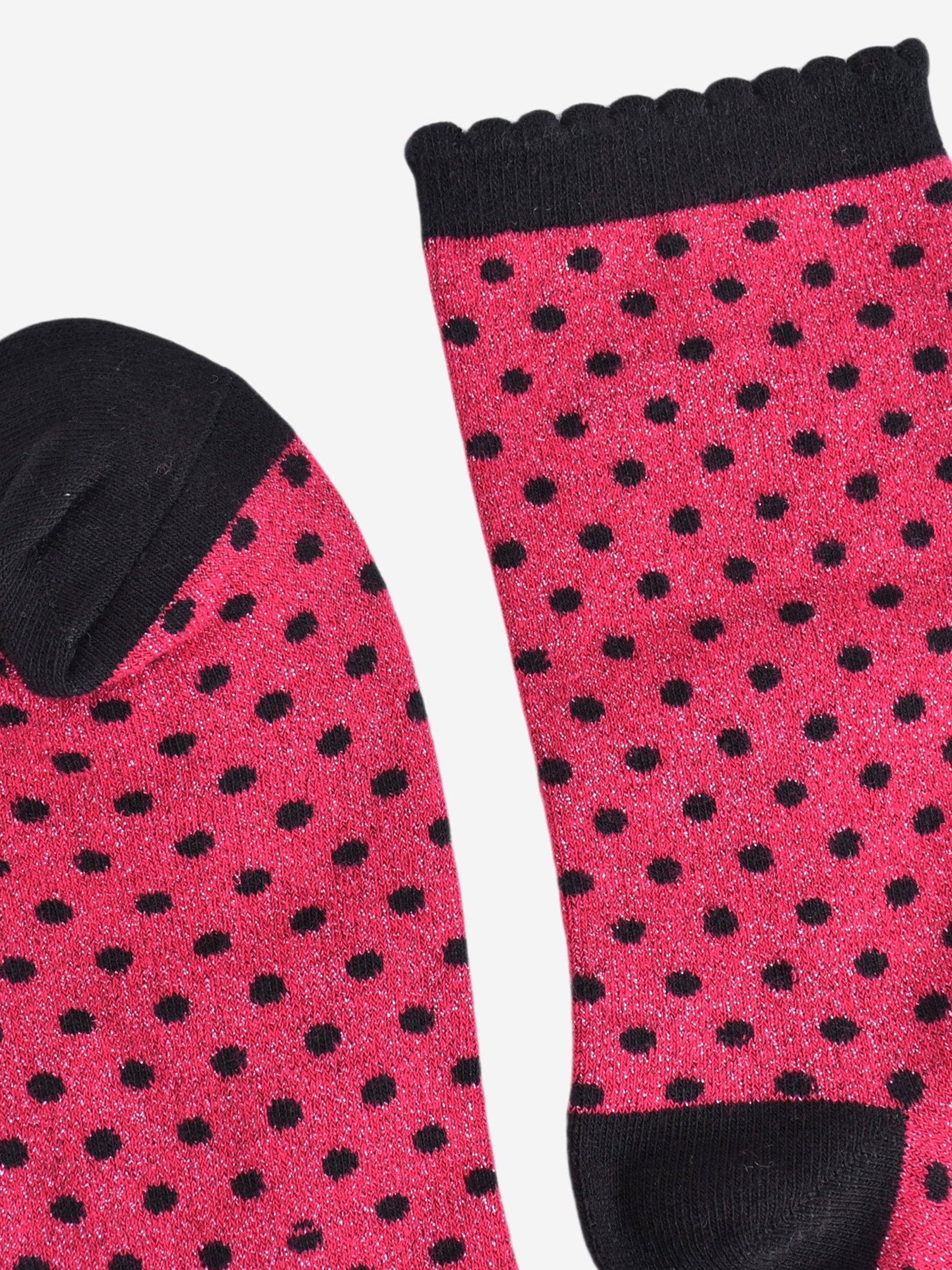 close up of the cuff and toe of the socks, they are both black and the cuff is scalloped