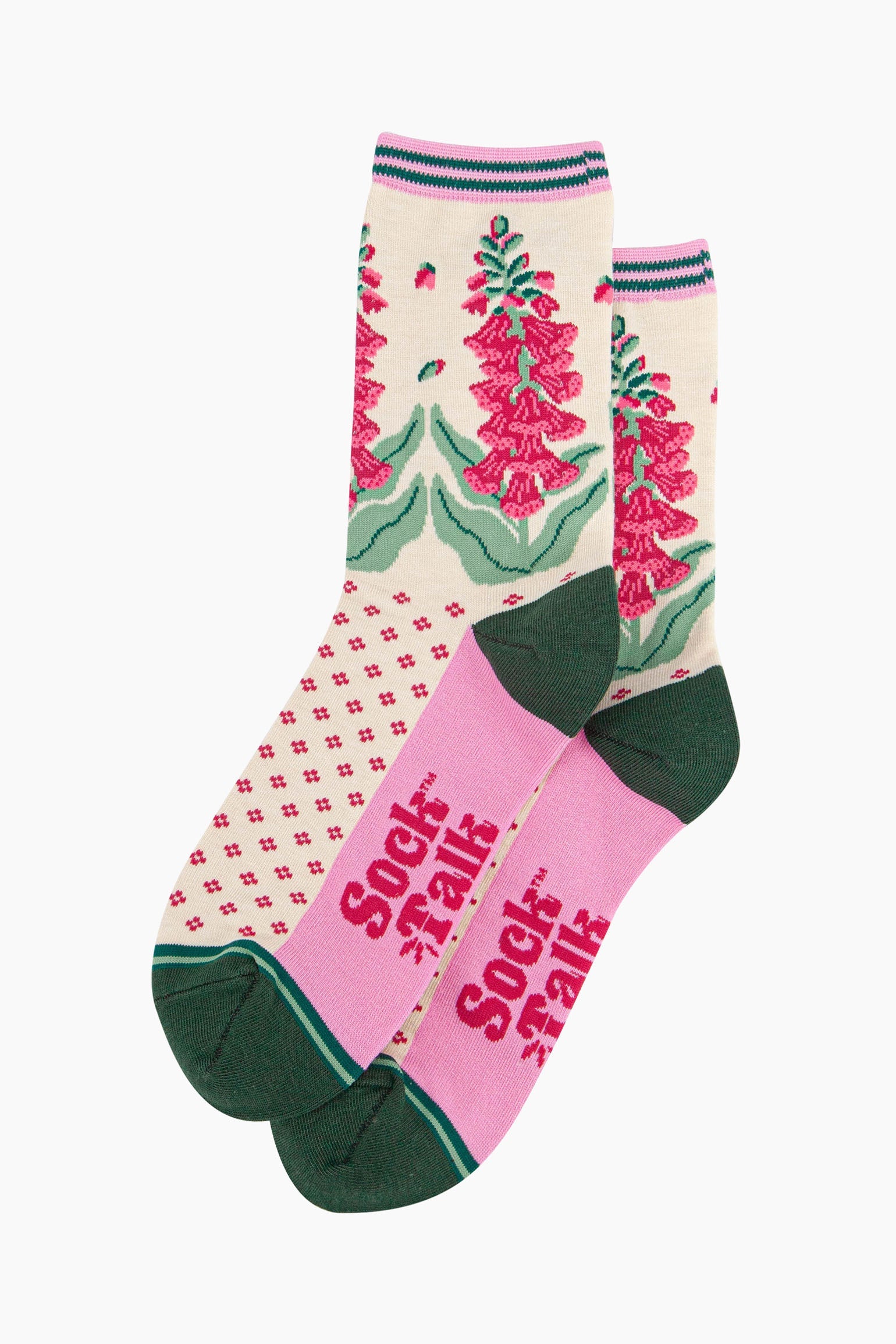 the pair of cream and pink foxglove socks laying flat one overlapping the other. showing clearly the cream background of the socks which is contrasted by a fuchsia pink dotted pattern. on the ankle of the socks there is a pattern of pink foxglove plants. the sock talk logo is fuchsia pink and  visible on the base of the sole.