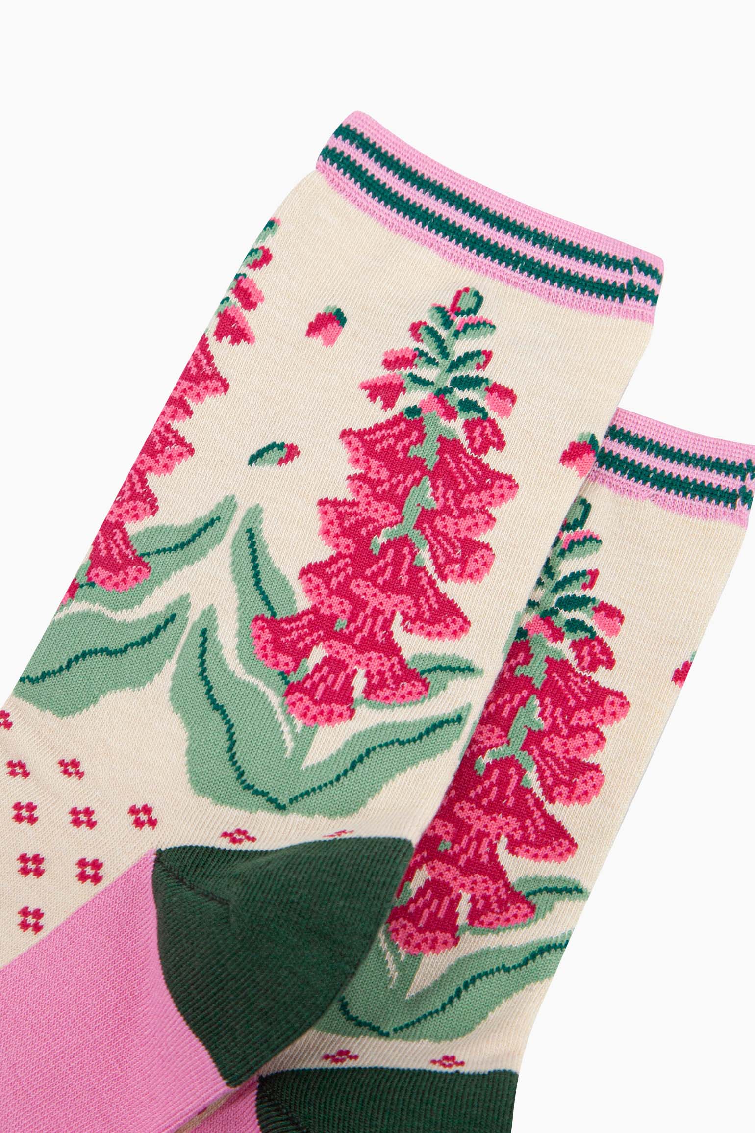 close up of the pattern. shown on the ankle are foxglove plants in full bloom. the flowers are fuchsia pink and they are shedding a few petals. 