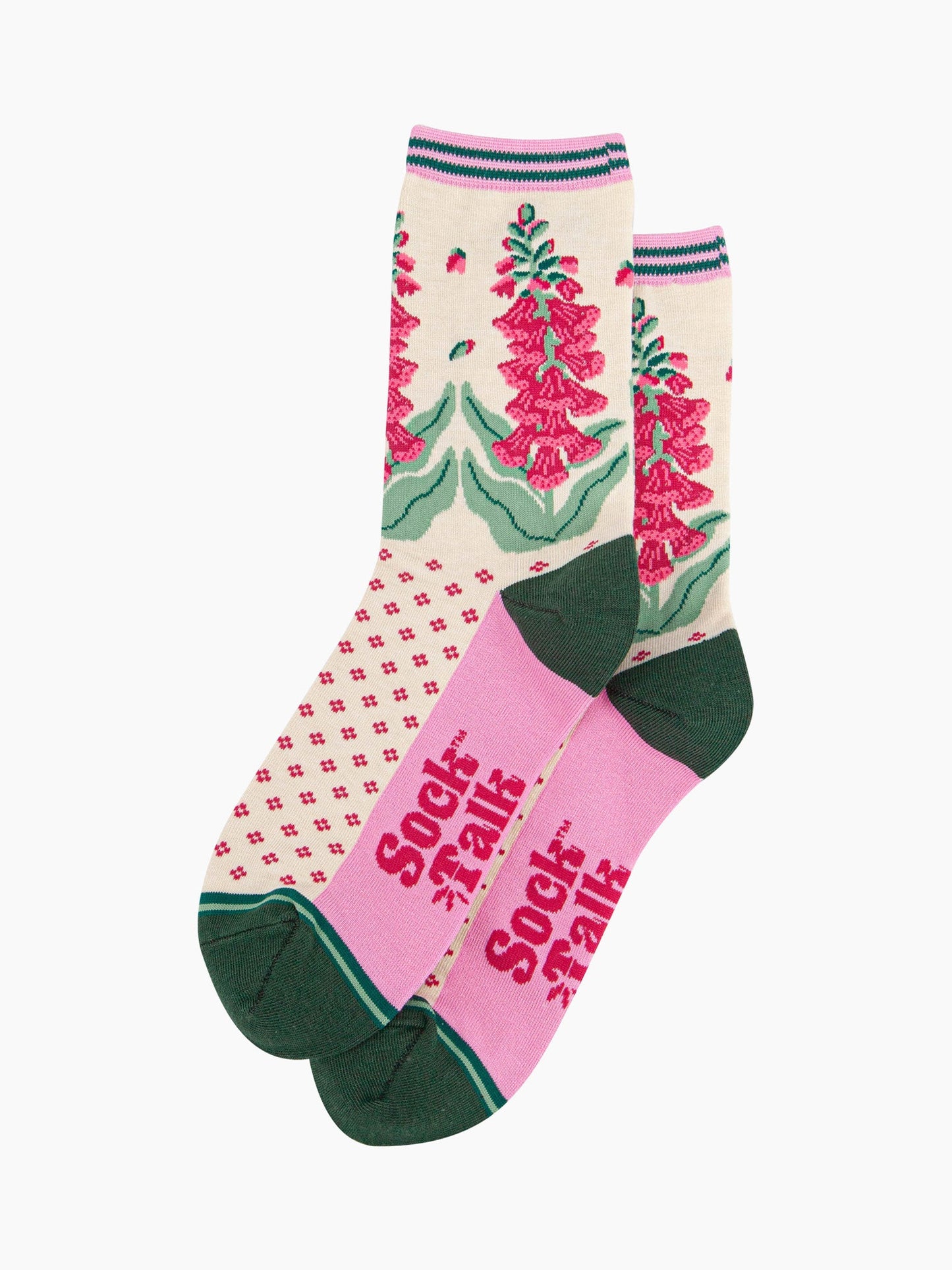 the pair of cream and pink foxglove socks laying flat one overlapping the other. showing clearly the cream background of the socks which is contrasted by a fuchsia pink dotted pattern. on the ankle of the socks there is a pattern of pink foxglove plants. the sock talk logo is fuchsia pink and  visible on the base of the sole.