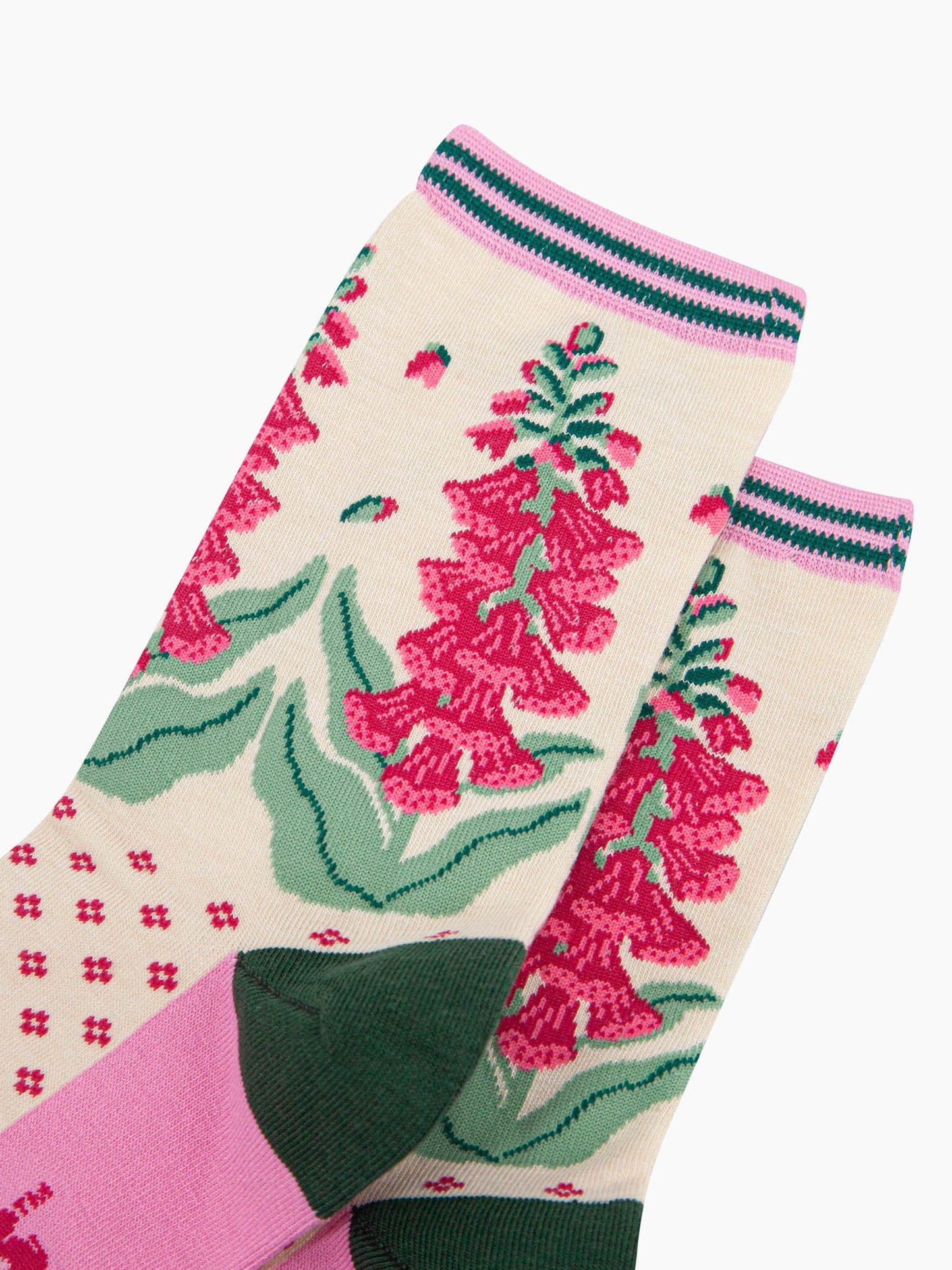 close up of the pattern. shown on the ankle are foxglove plants in full bloom. the flowers are fuchsia pink and they are shedding a few petals. 