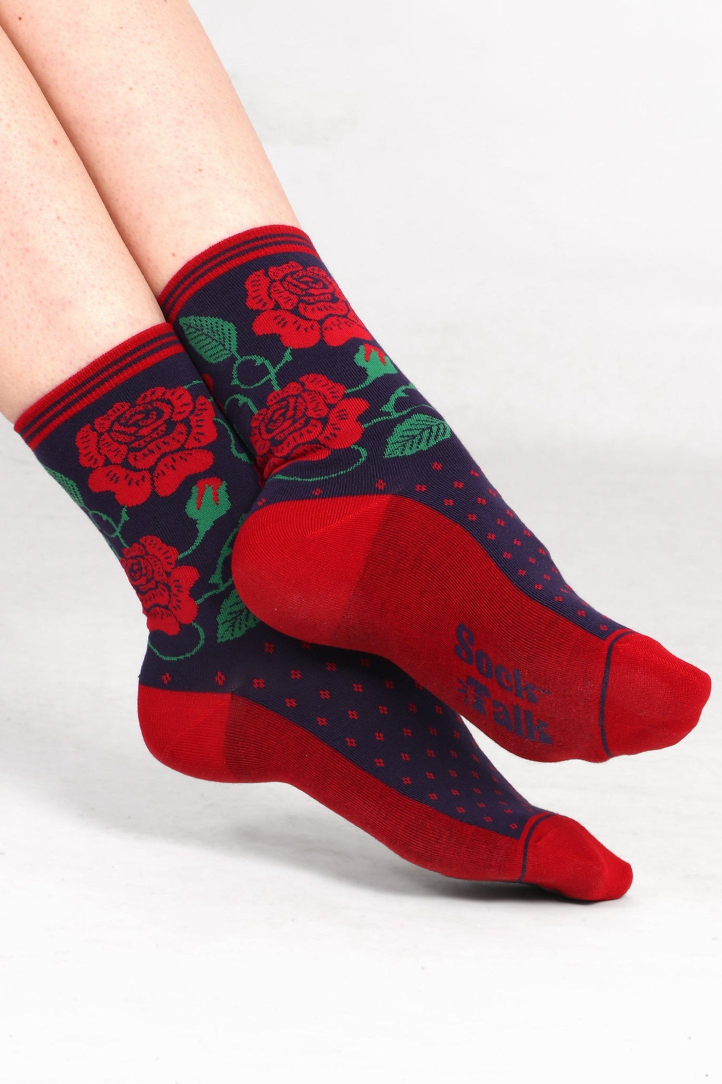 Women's model feet wearing english rose print bamboo socks. Feet are angled to show sock talk branding on the sole