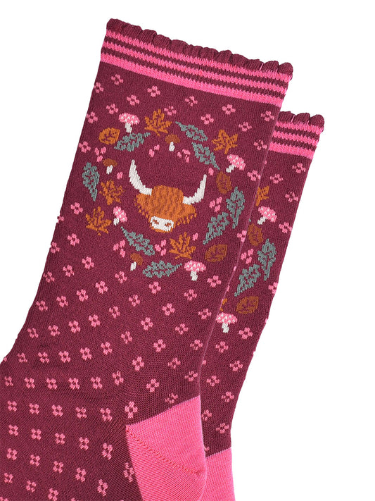 close up of the highland cow and wreath design which shows the head of a highland cow surrounded by autumn leaves and pink toadstools