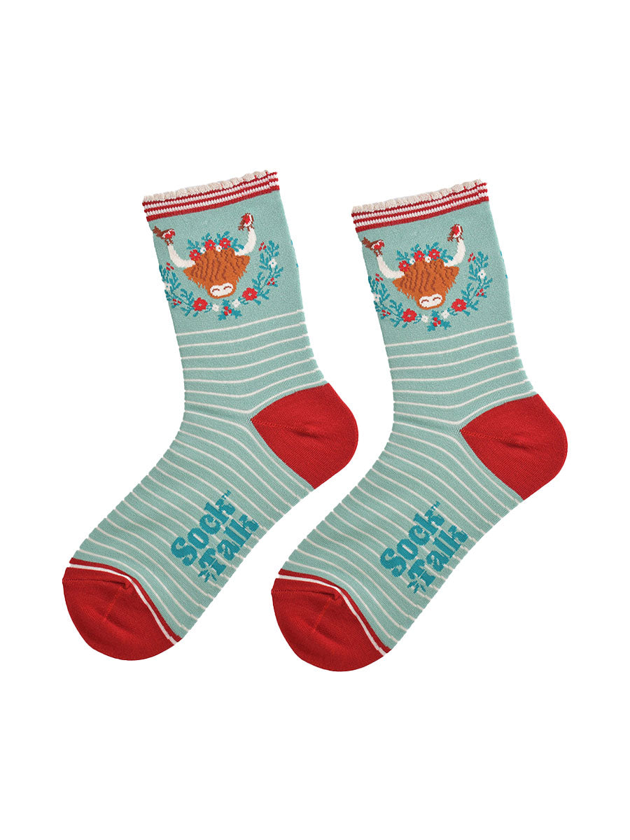 showing the socks laying flat, highlighting the white pinstripe pattern and large highland cow and wreath design on the ankle of the socks