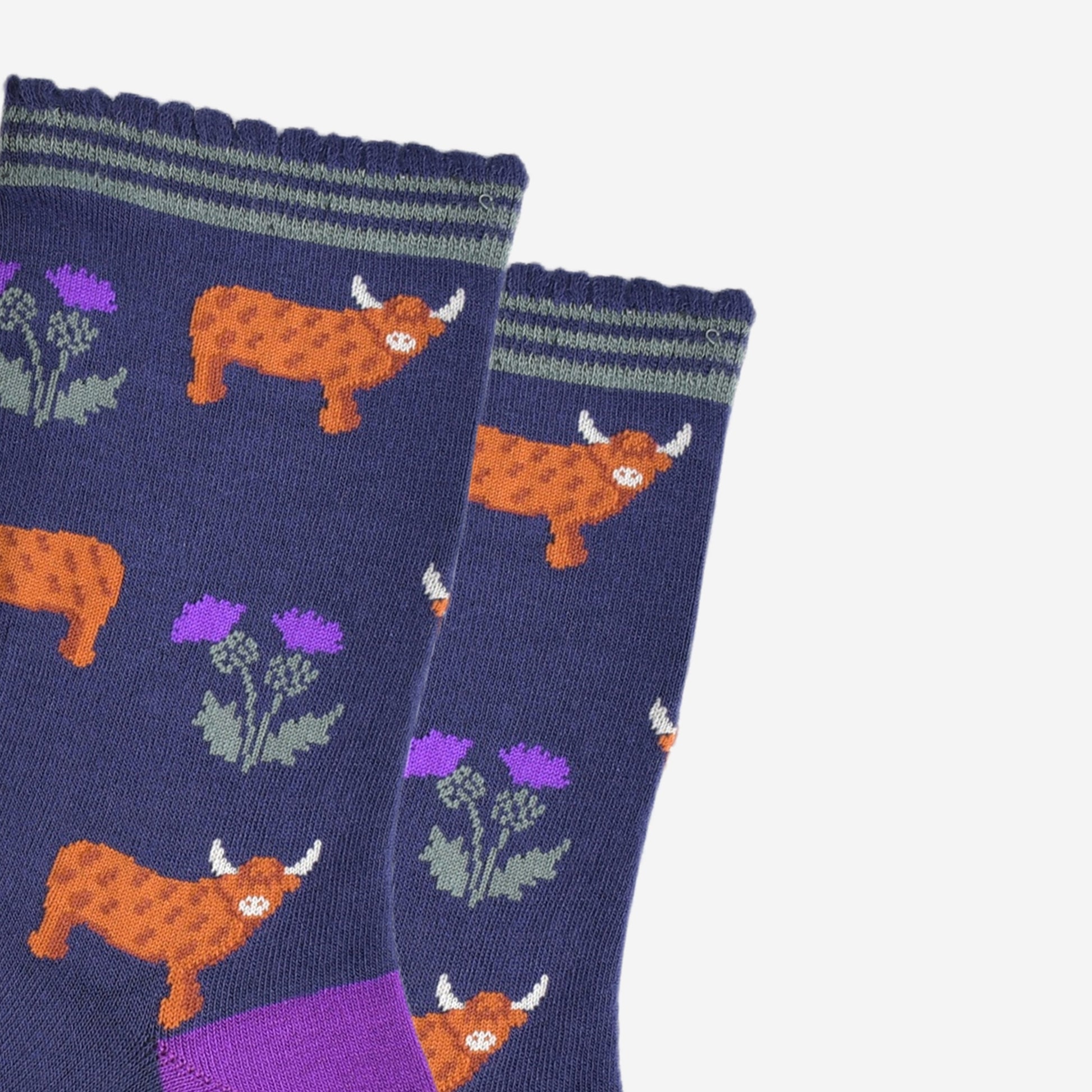 close up of the highland cow and thistle pattern, the highland cows are standing in profile  and the thistles are twin headed