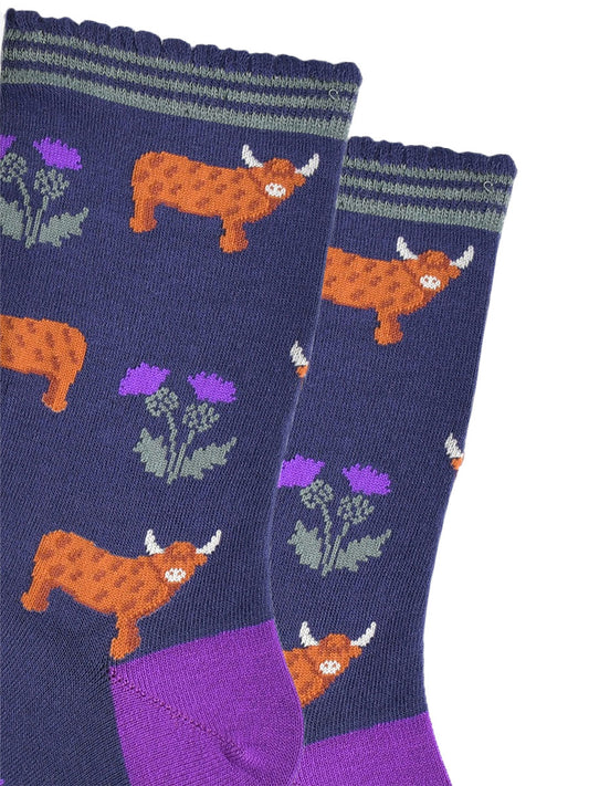 close up of the highland cow and thistle pattern, the highland cows are standing in profile  and the thistles are twin headed