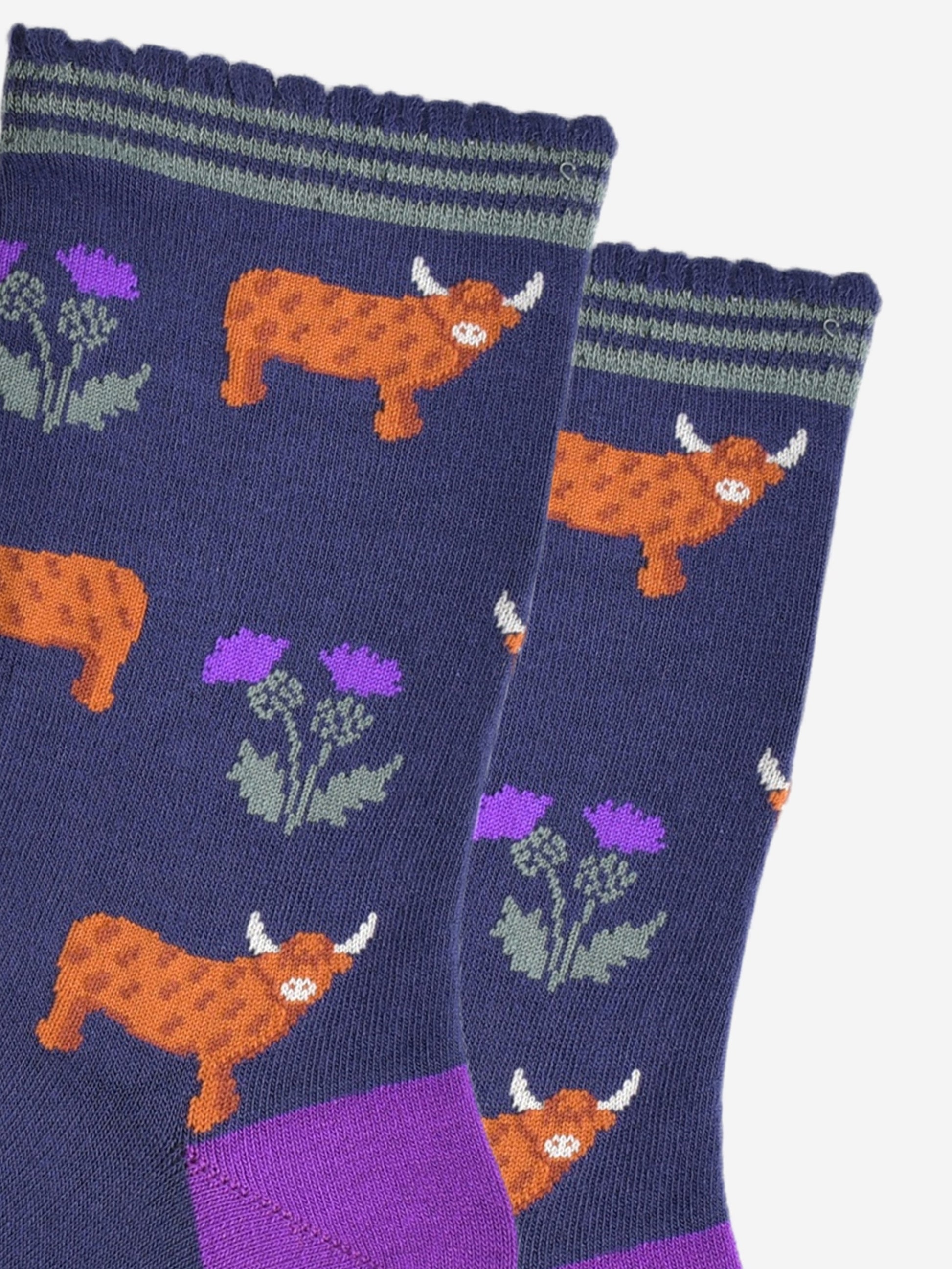 close up of the highland cow and thistle pattern, the highland cows are standing in profile  and the thistles are twin headed