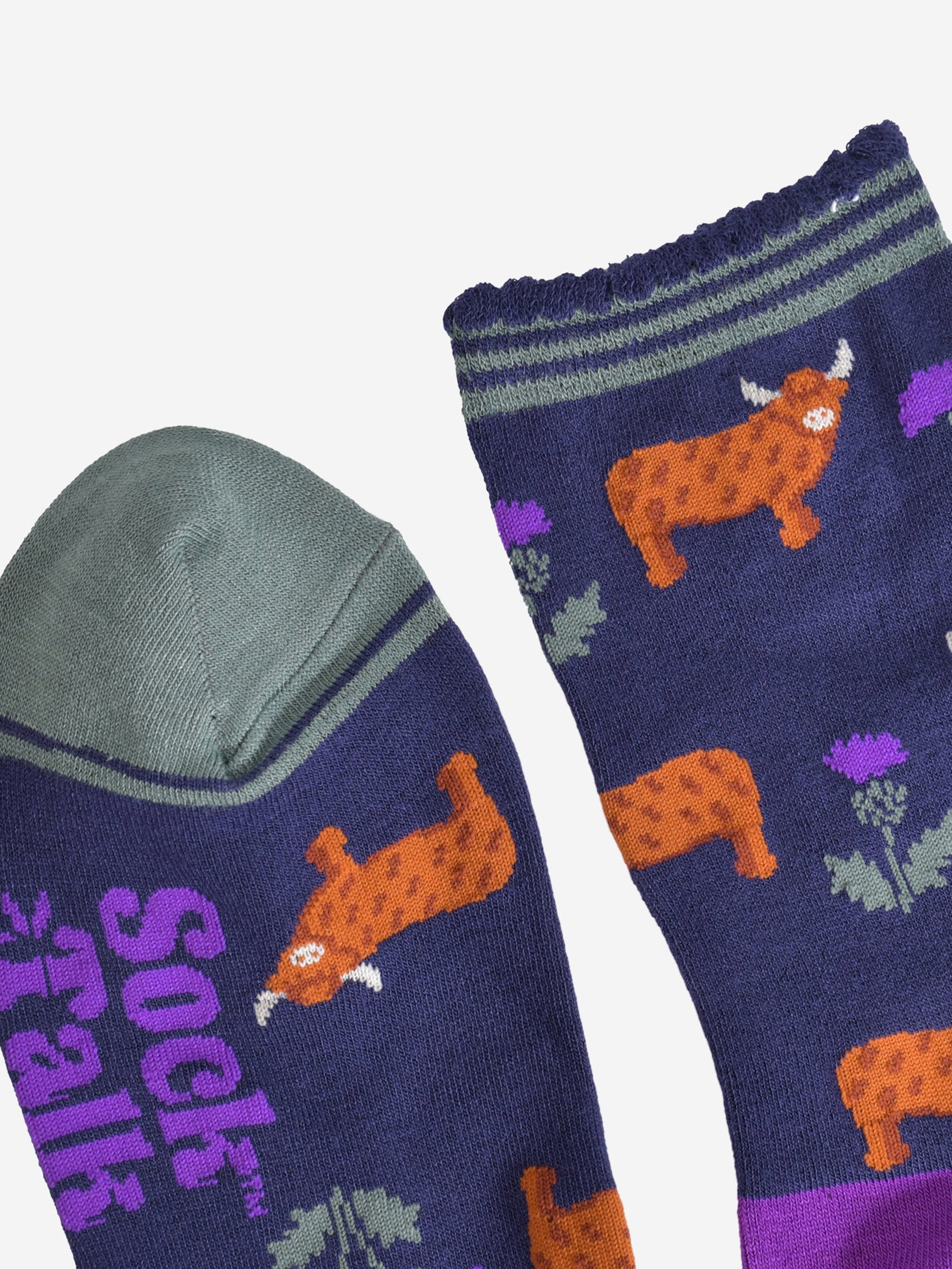 close up of the cuff and toe of the socks, the toe is green and the cuff had three green thin horizontal stripes and a scalloped edge