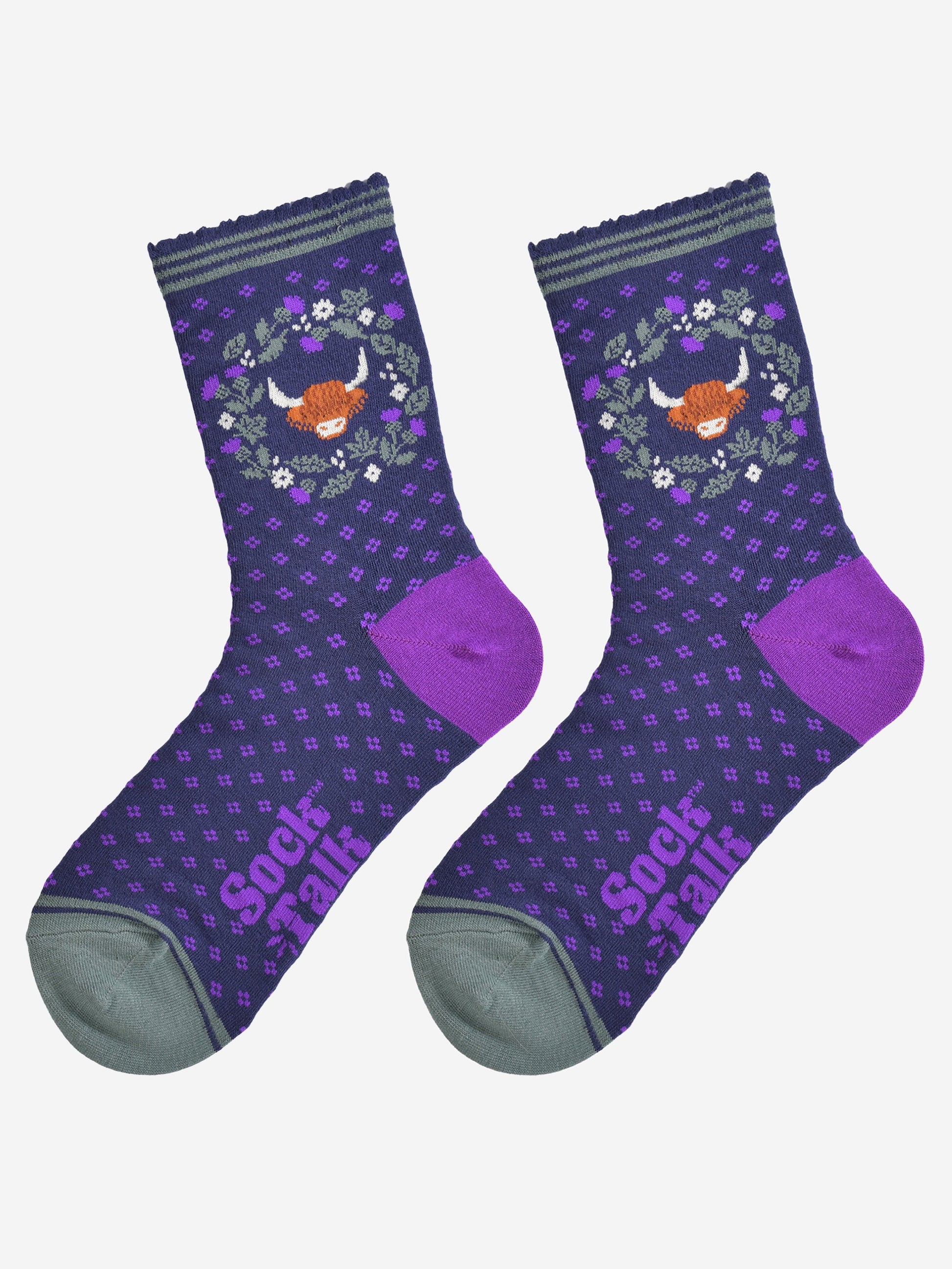 highland cow and wreath bamboo socks laying flat, showing the all over purple spotted pattern, green and purple thistle flower wreath and highland cow