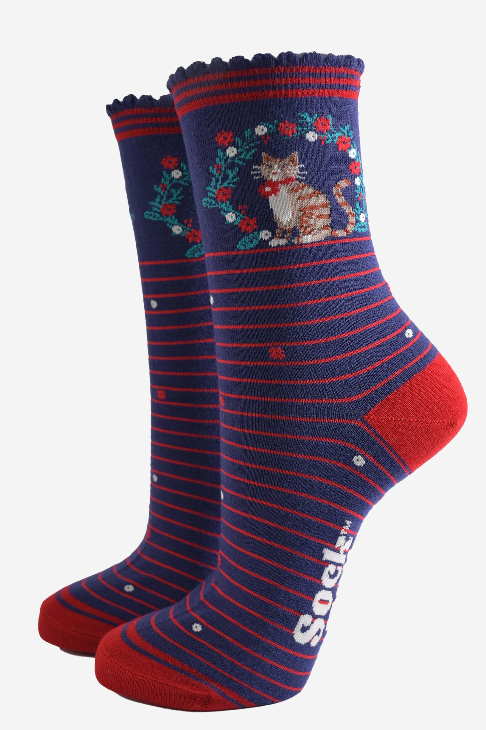 navy blue socks with red stripes, on the ankle there is a tabby cat surrounded by a festive floral wreath