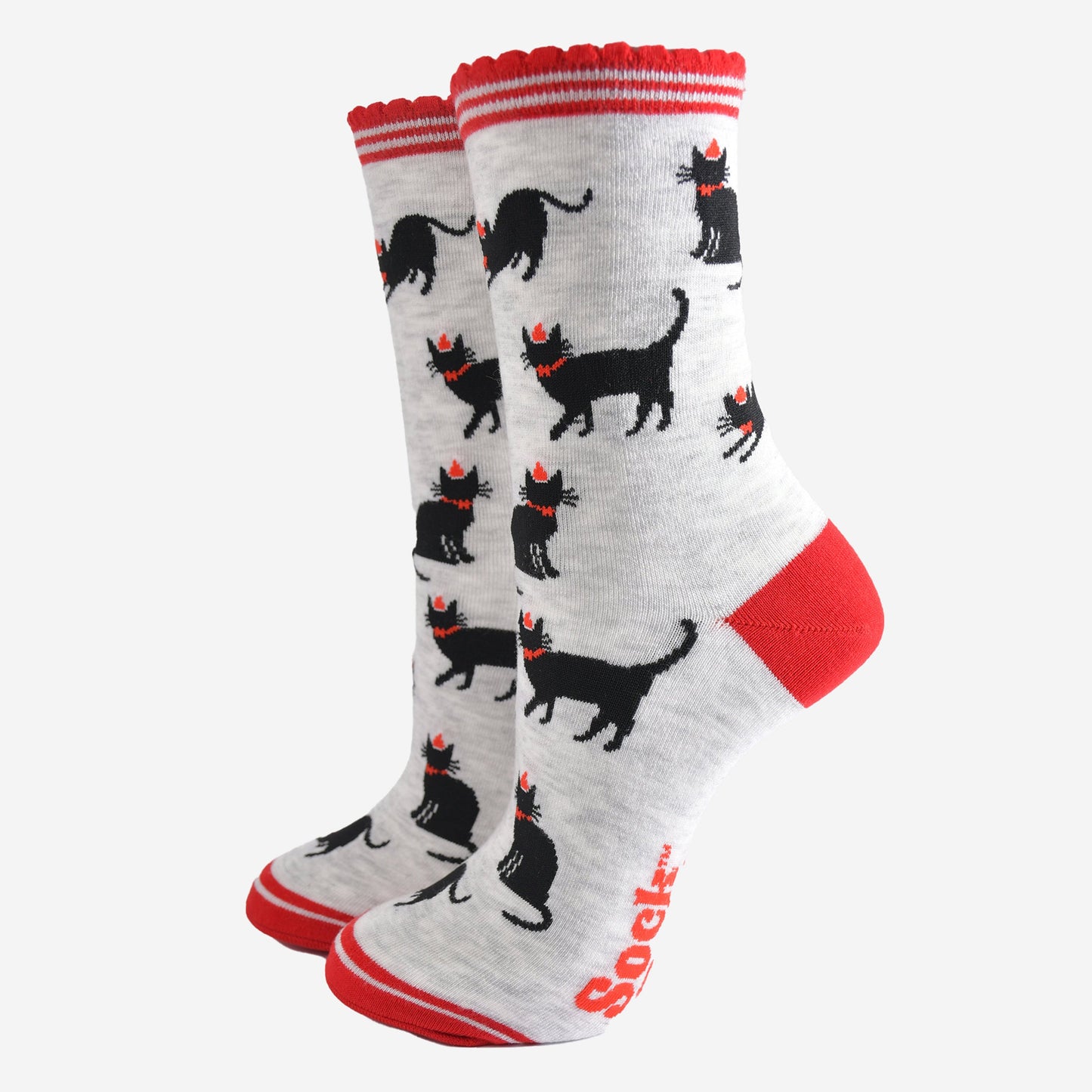 light grey socks with black cats wearing festive party hats, the socks have red striped scalloped cuffs, red toe and heel