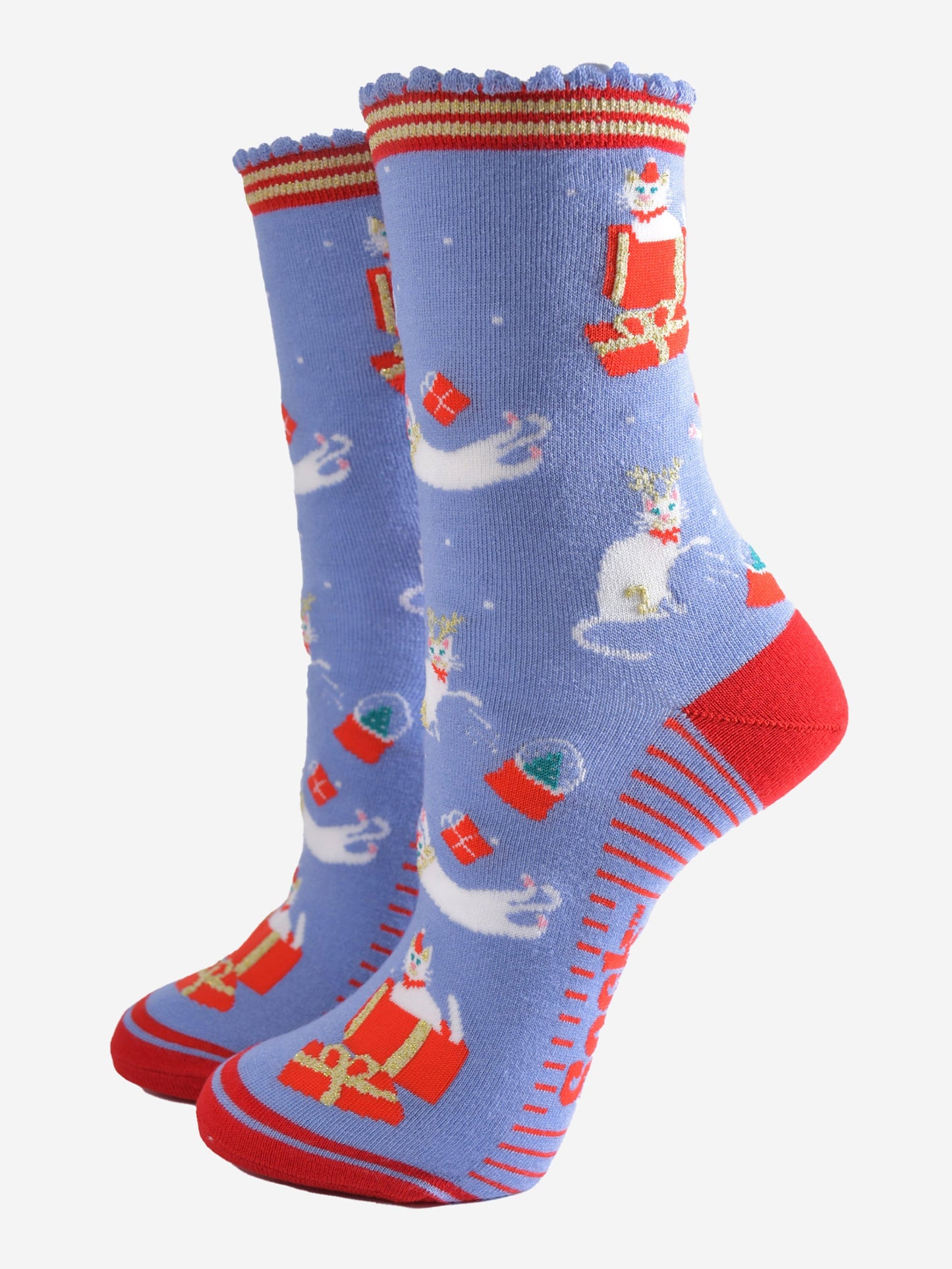 light blue socks with a contrasting red heel, toe and striped cuff and sole with a pattern of white cats playing with snow globes and christmas presents