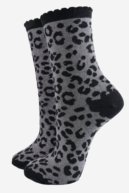 grey ankle socks with a black leopard print pattern, all over glitter sparkle and black scalloped cuff