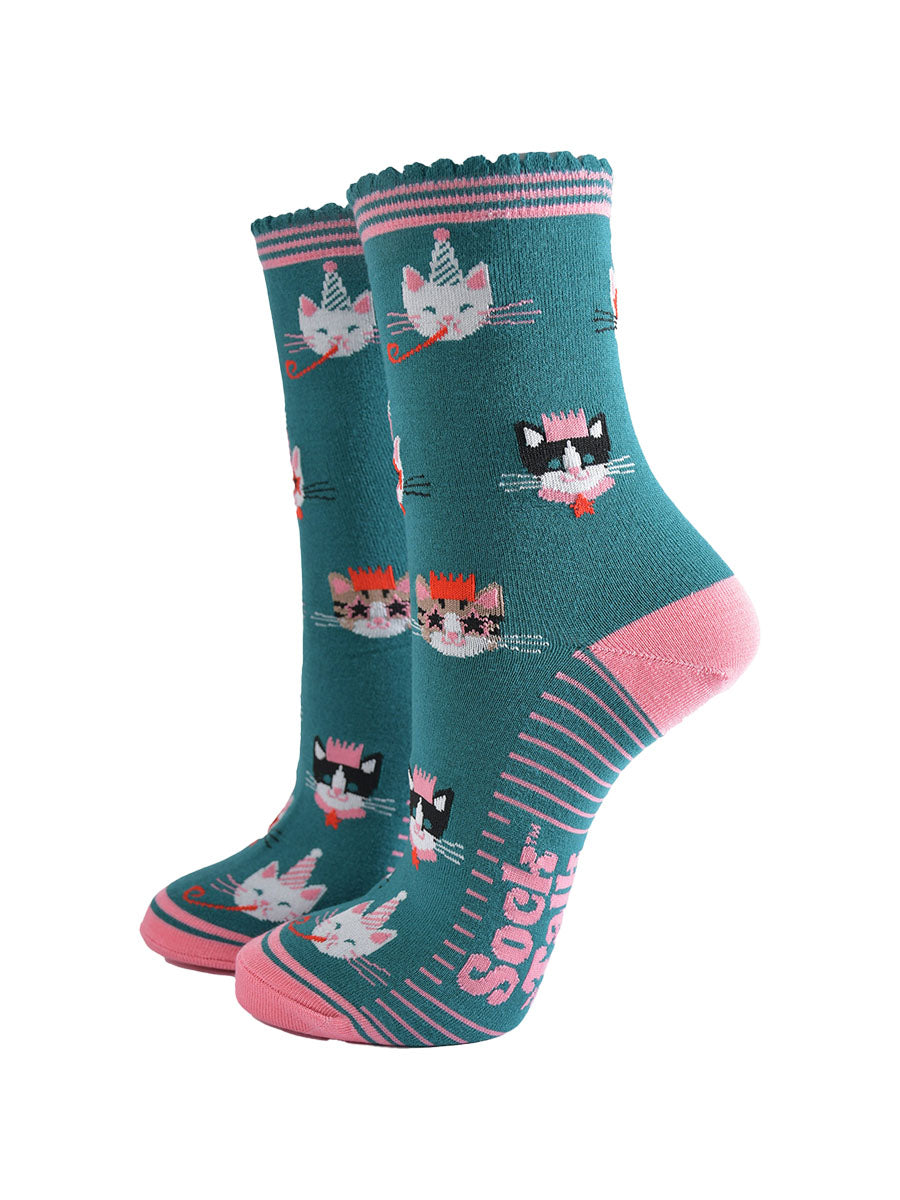 teal green socks with pink heel, toe and striped cuff with an all over pattern featuring cats wearing party hats