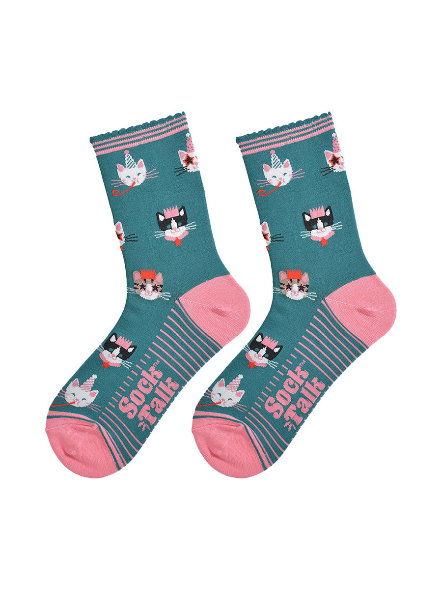 showing the green party cat socks laying flat, the sole has pink stripes and the cat face pattern is all over the socks.