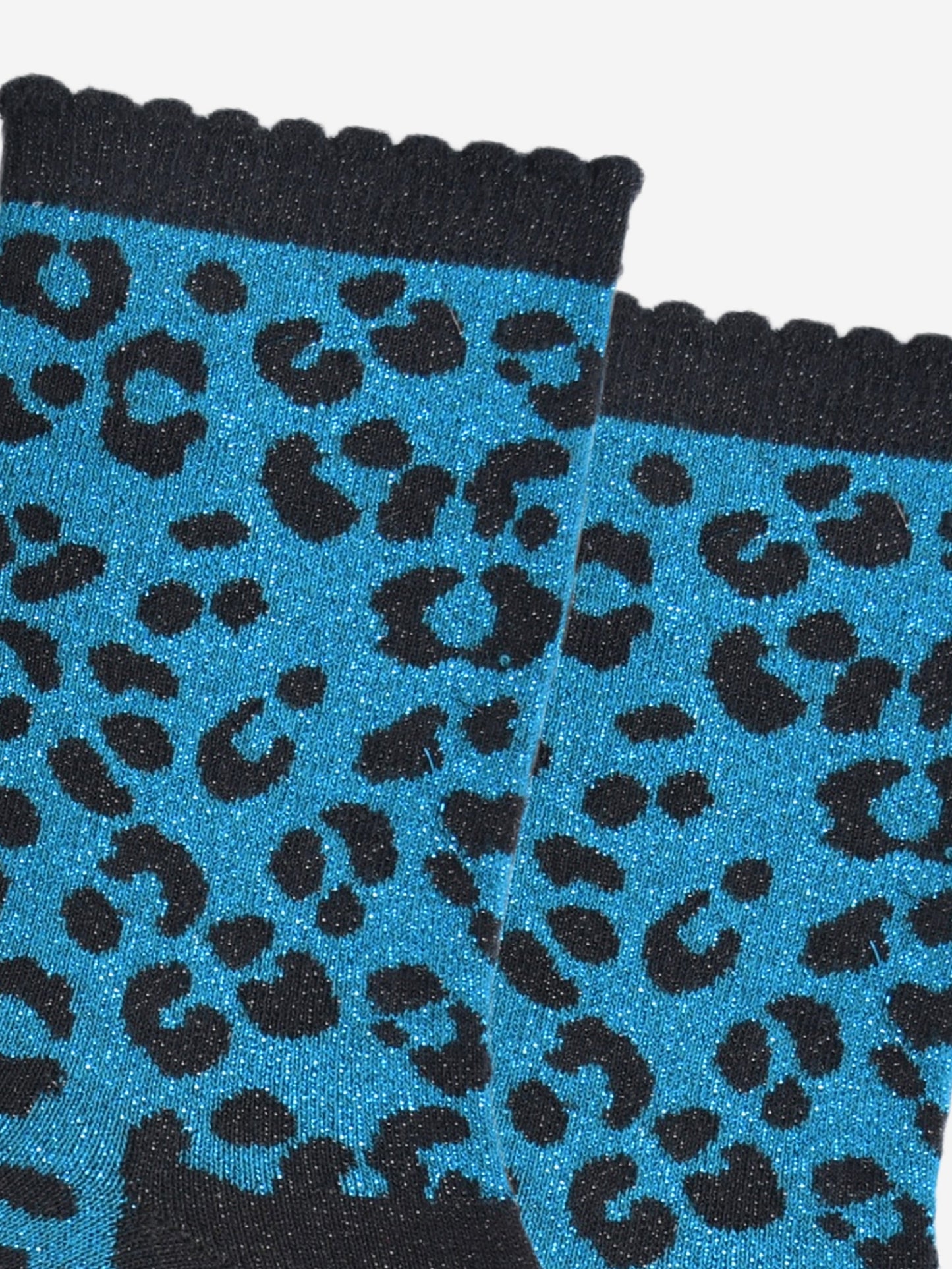 close up of the teal leopard print pattern on the socks, there is a visible silver glitter sparkle all over the design. the teal blue print contrasts with the black base of the socks