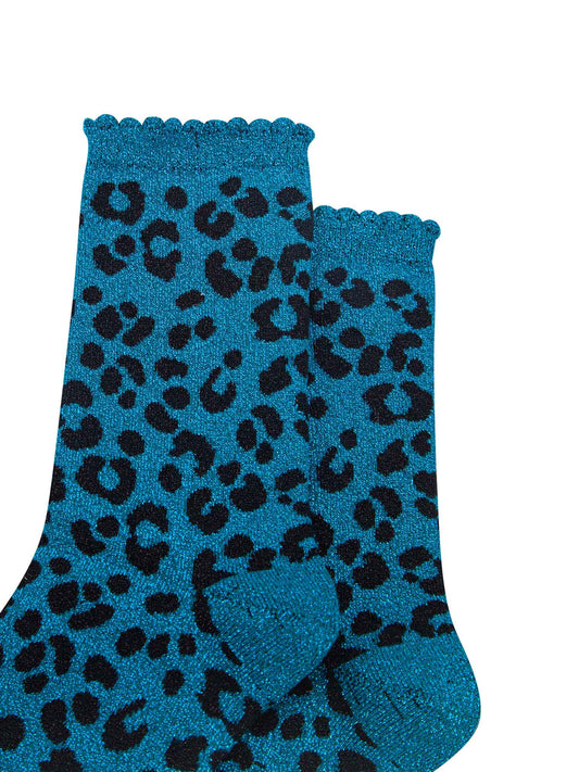 close up of the teal leopard print pattern on the socks, there is a visible silver glitter sparkle all over the design. the teal blue print contrasts with the black base of the socks