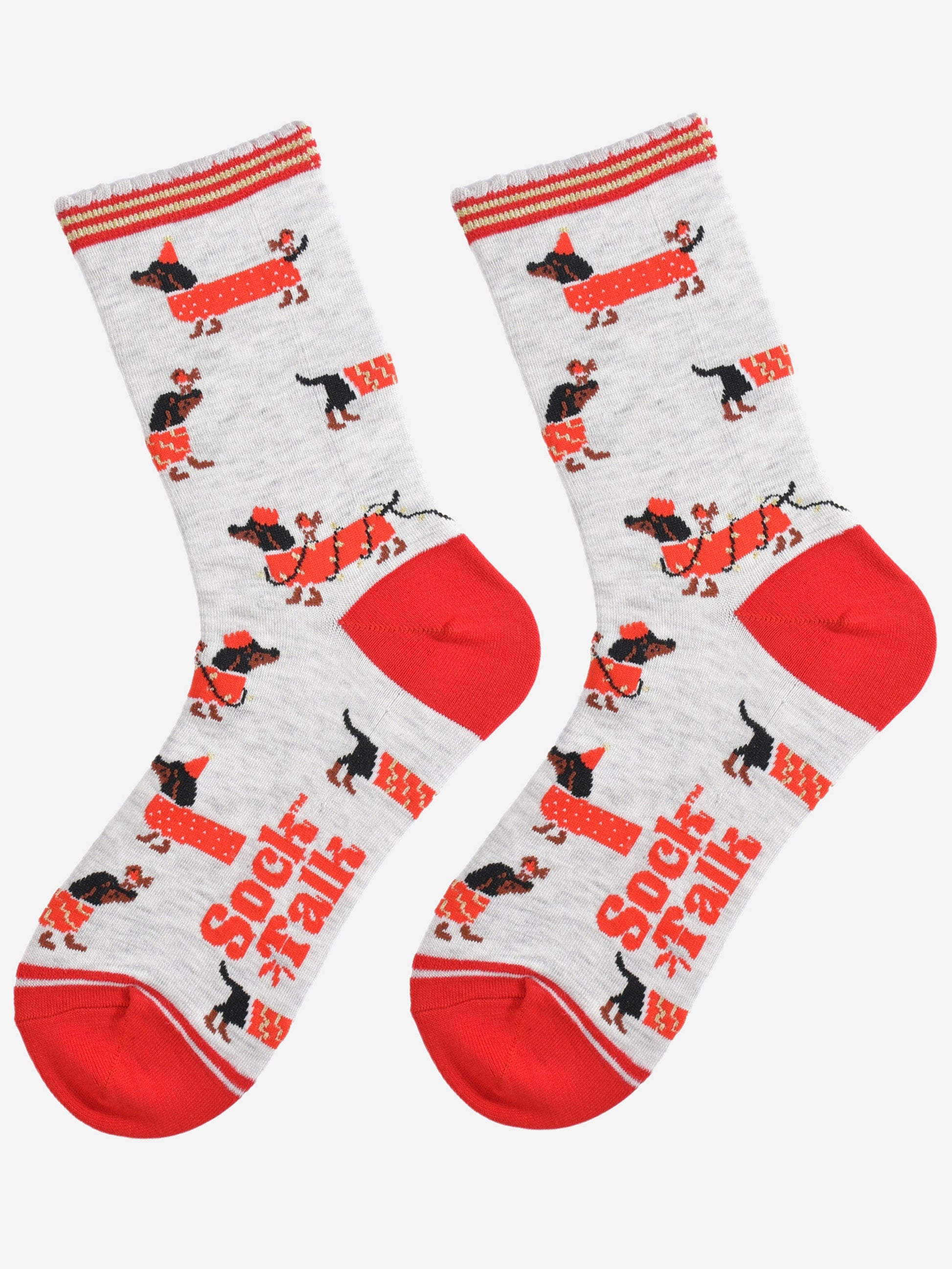 showing the socks laying flat, there is an all over pattern of black sausage dogs wearing red festive coats, party lights and hats. there are also red robins playing with the sausage dogs
