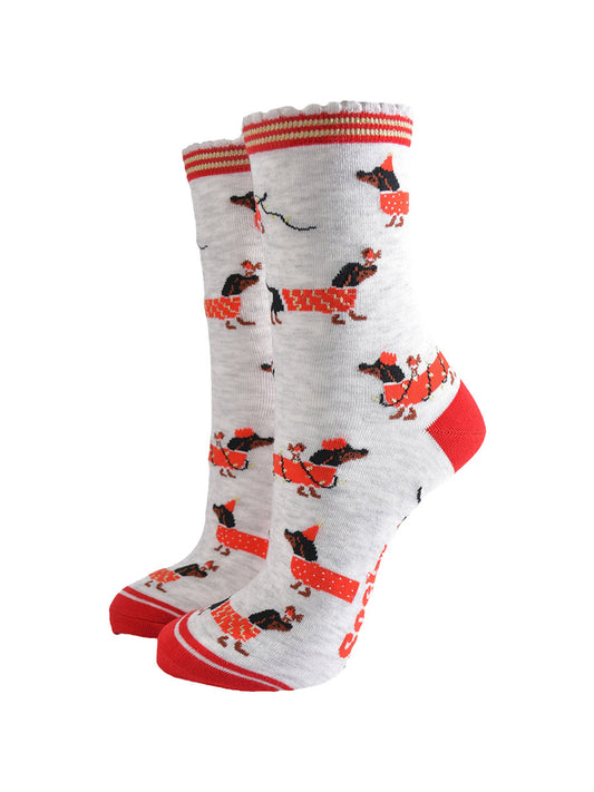 light grey socks with a red heel, toe and cuff with a  pattern of dachshunds wearing xmas lights, jumpers and playing with red robin birds
