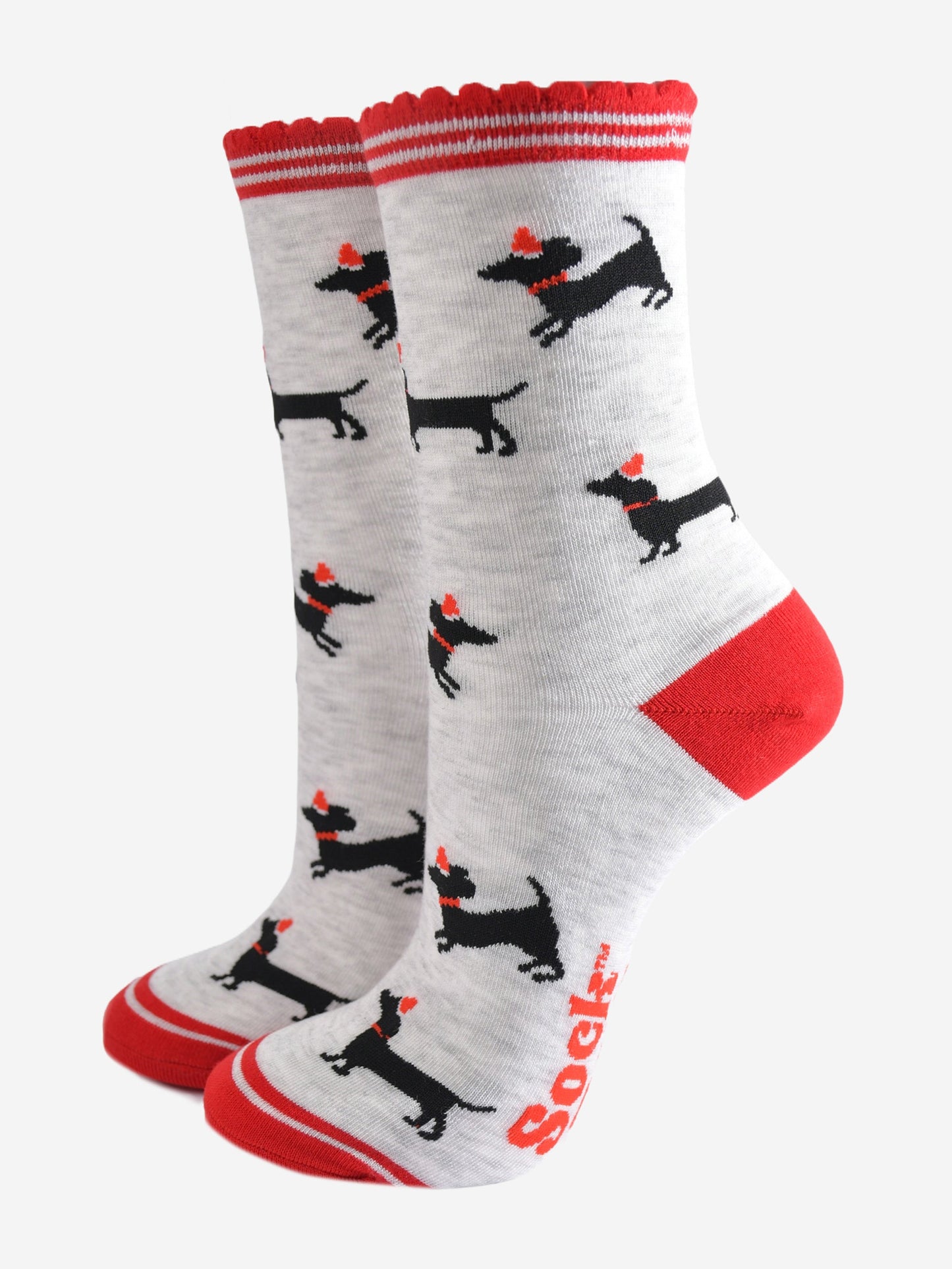 light grey socks with red heel, toe and scalloped cuff with an all over pattern of black sausage dog silhouettes wearing red santa party hats