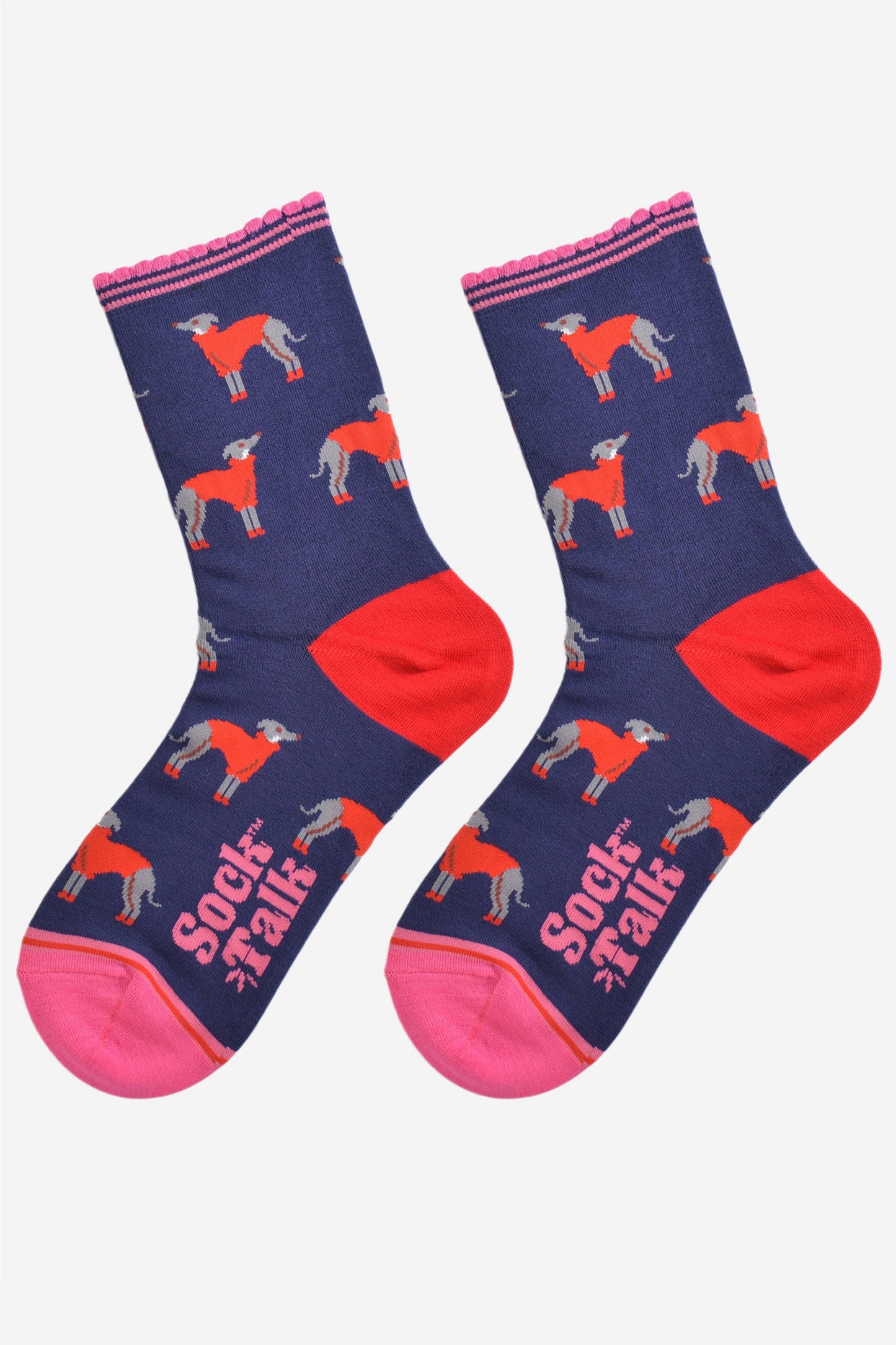 showing the greyhound socks laying flat, the heel is red and the toe and cuff are pink in contrast to the navy blue background of the socks. the greyhound dog pattern is all over the body of the socks