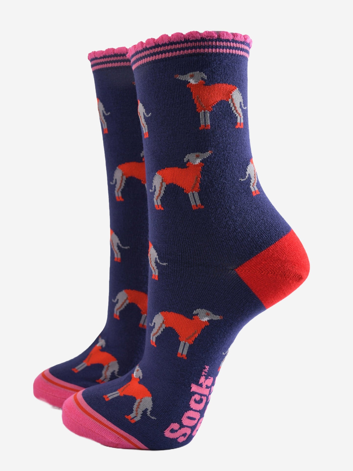 navy blue ankle socks with a pink scalloped cuff, with a pattern of greyhound dogs wearing cosy red knitted jumpers