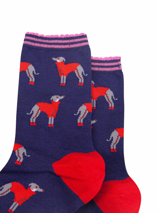 close up of the greyhound pattern on the socks, the grey hounds are grey with white necks, they are wearing red winter coats and red booties